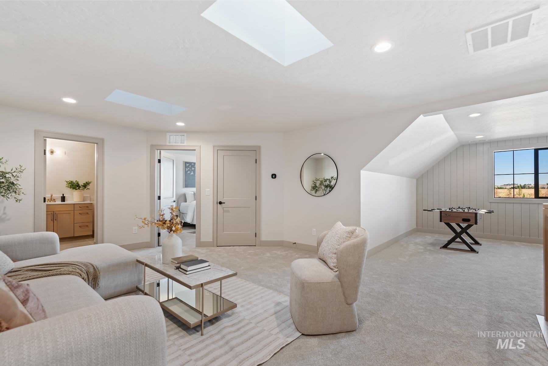 Carpeted living area featuring a skylight, recessed lighting, and vaulted ceiling