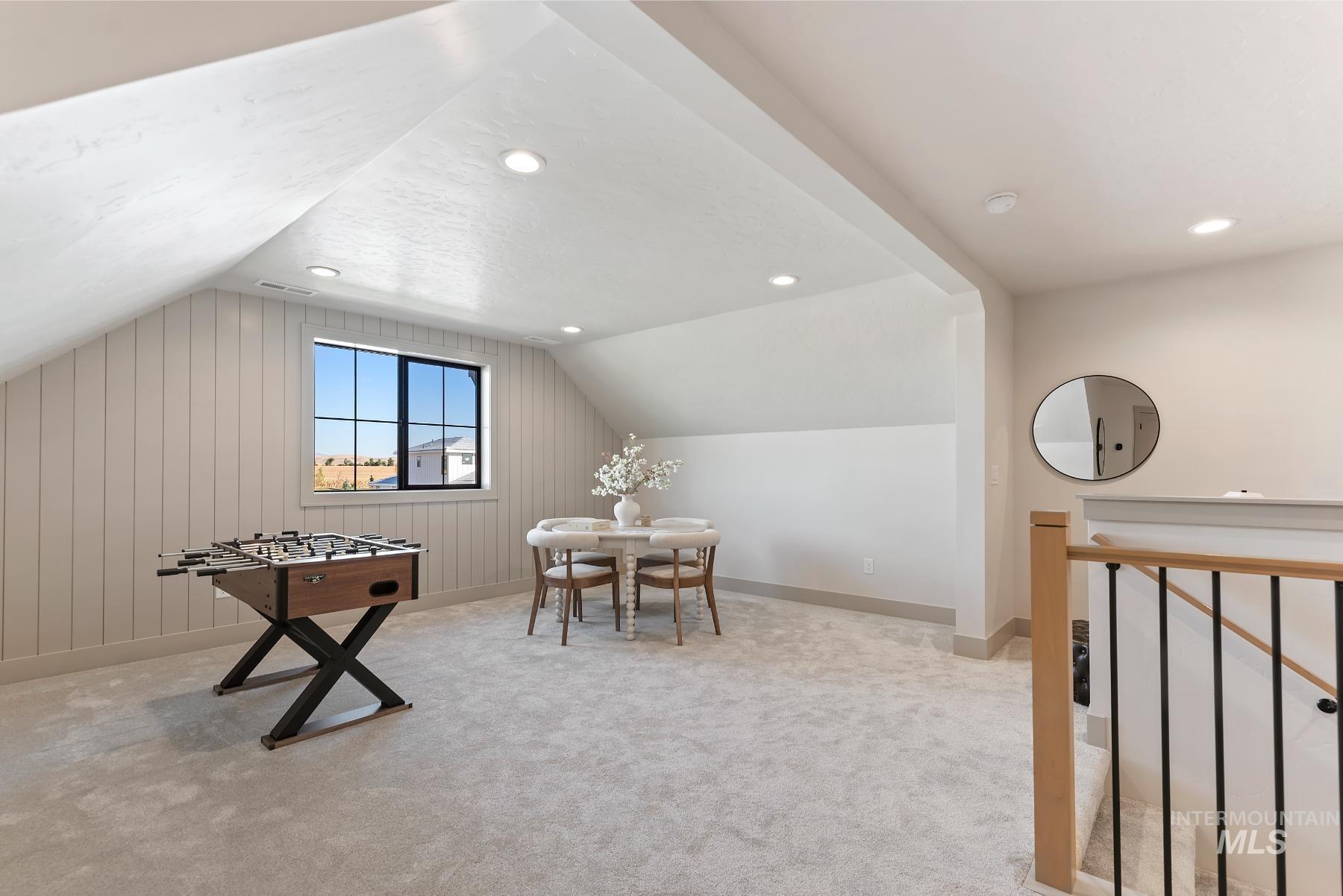 Recreation room with vaulted ceiling, light colored carpet, and recessed lighting