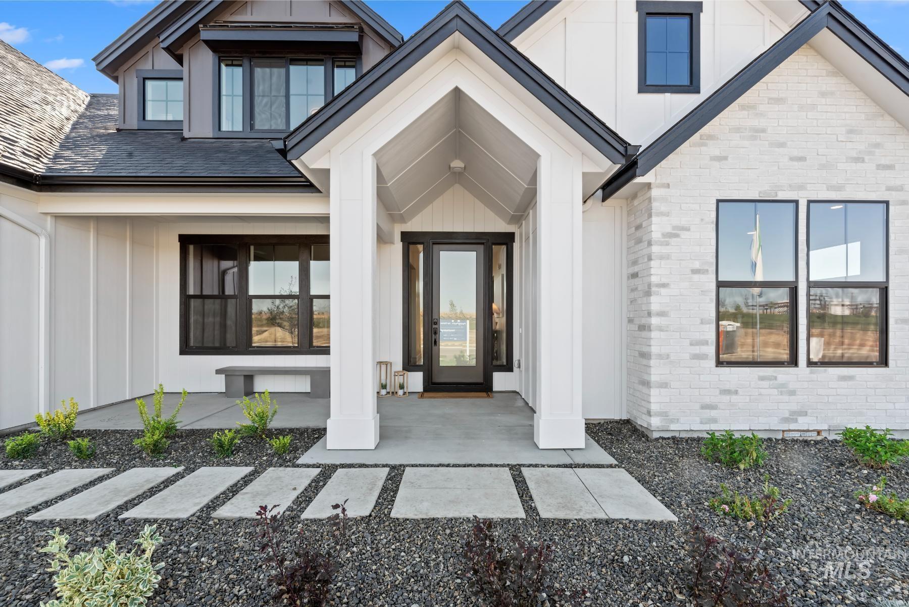 Property entrance with board and batten siding, brick siding, and a porch