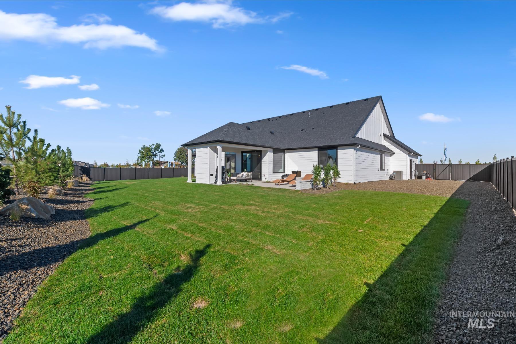 Rear view of house featuring a fenced backyard and a patio