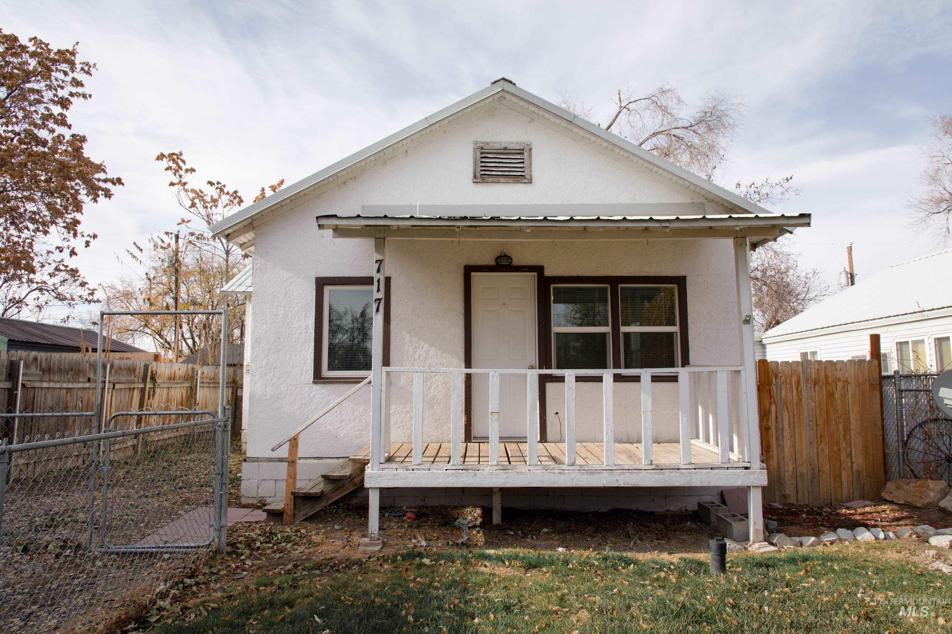 Rear view of house with a fenced backyard, a wooden deck, and stucco siding