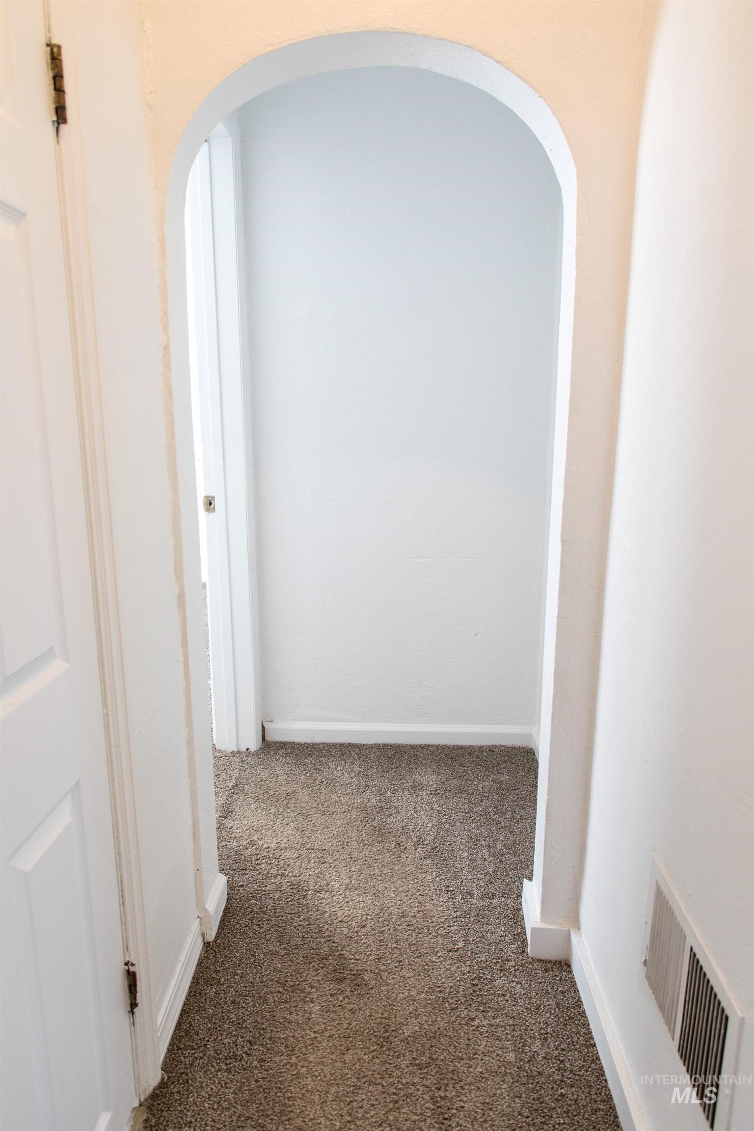 Corridor with arched walkways and carpet floors