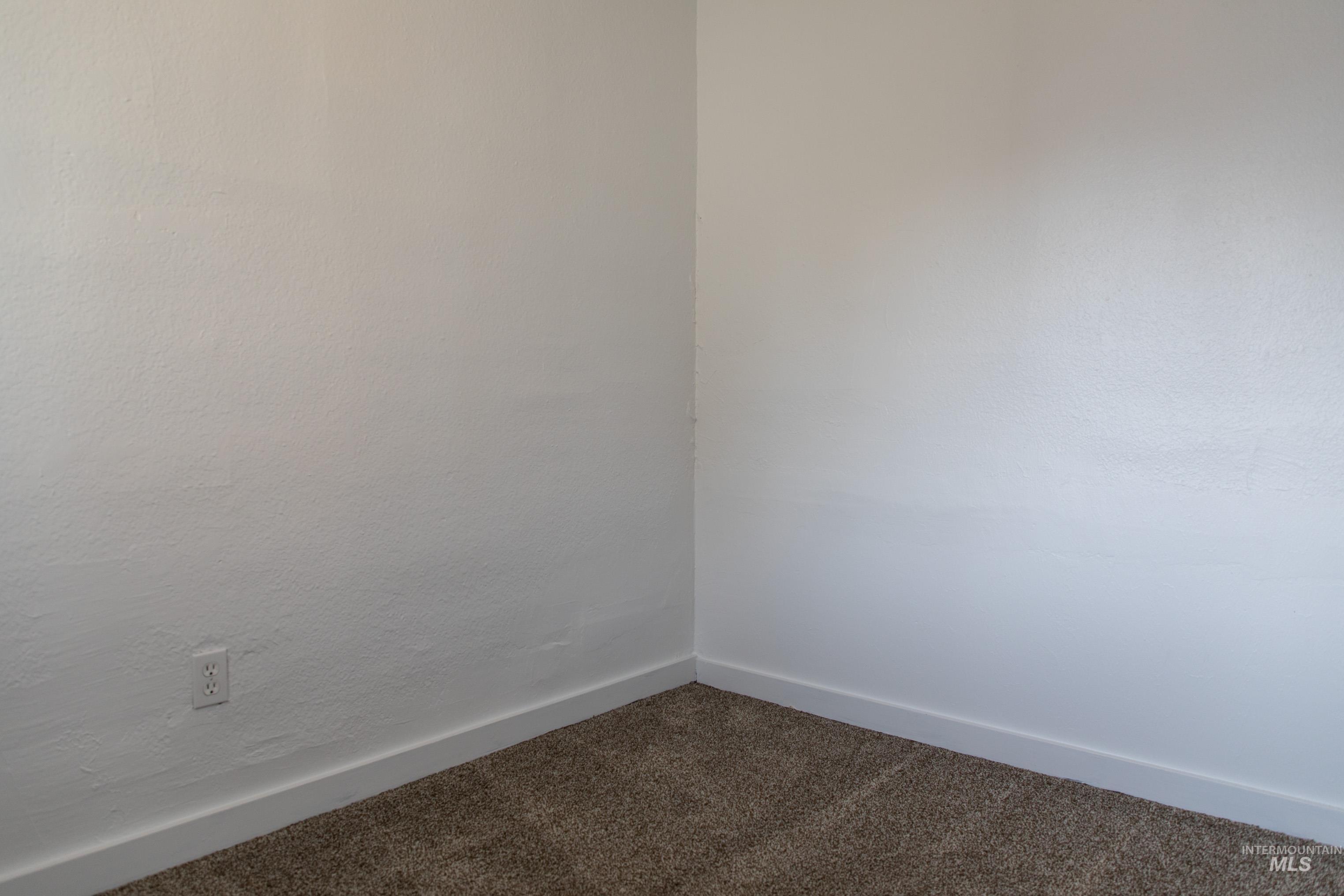 Carpeted spare room with baseboards
