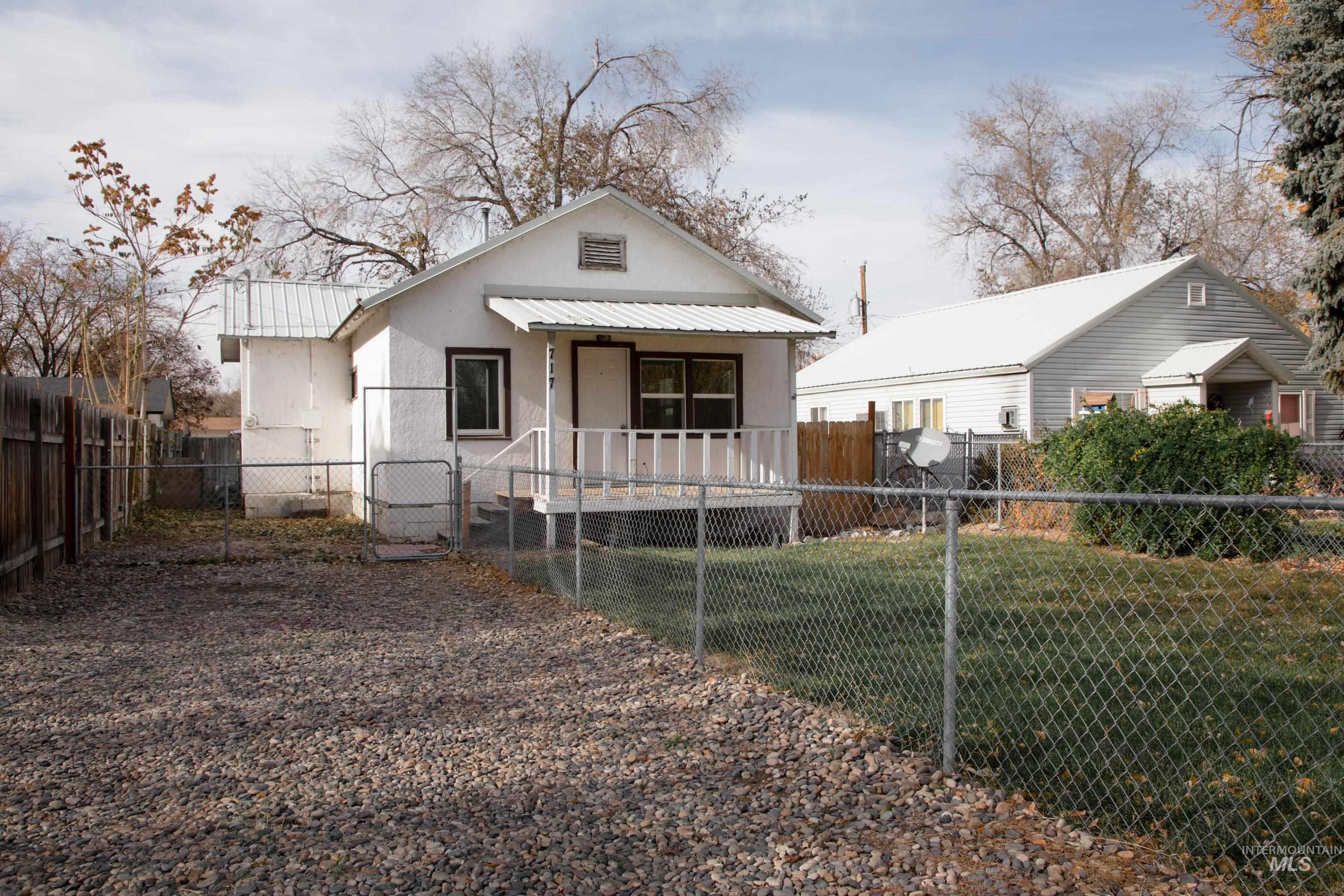 Rear view of property with a fenced front yard, stucco siding, and a gate