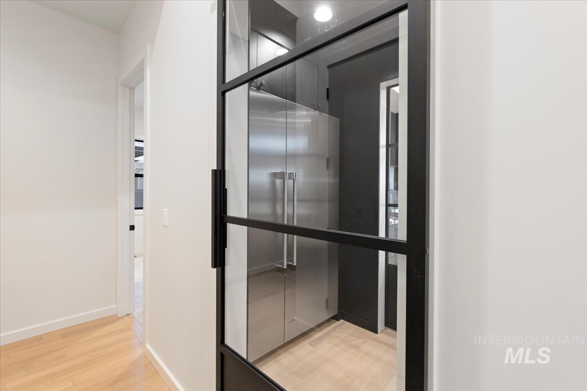 Barn door to pantry featuring light wood finished floors