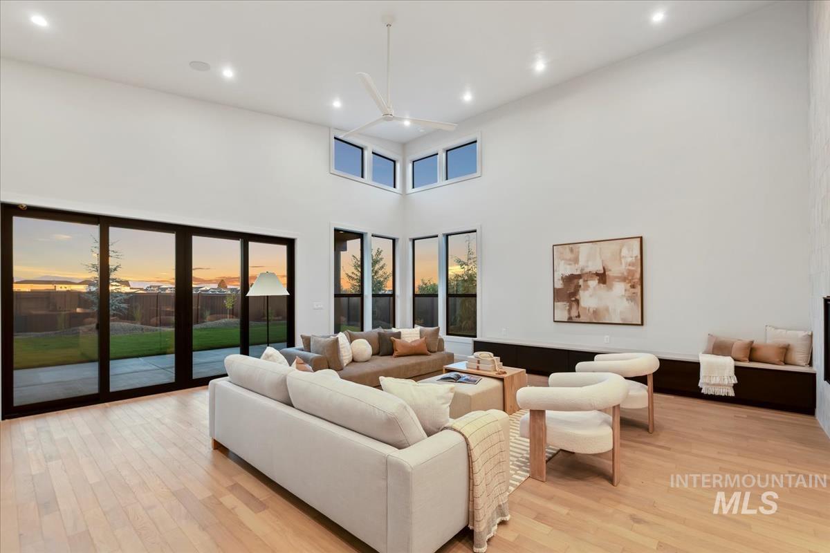 Living room with light wood-style flooring, recessed lighting, and a high ceiling