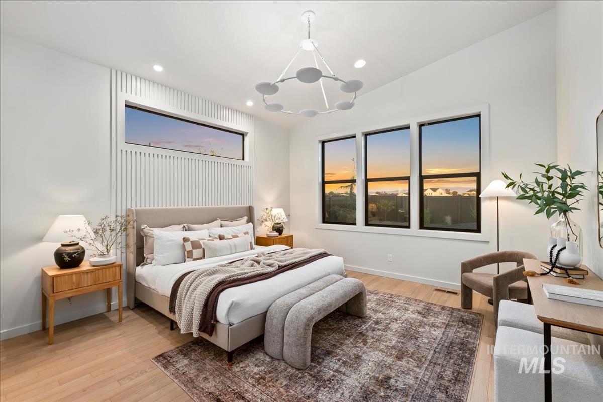 Bedroom with light wood-type flooring, recessed lighting, and vaulted ceiling