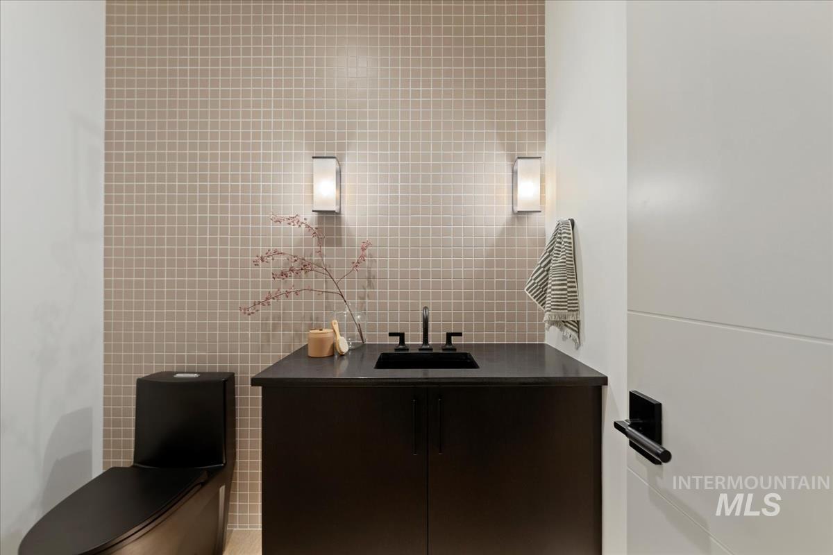 Bathroom featuring tile walls and vanity