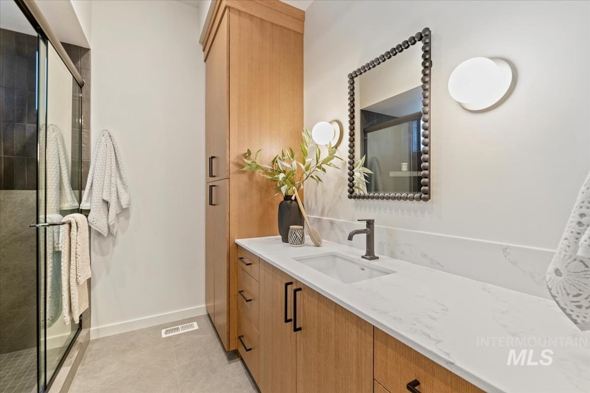 Bathroom featuring vanity, a stall shower, and light tile patterned floors