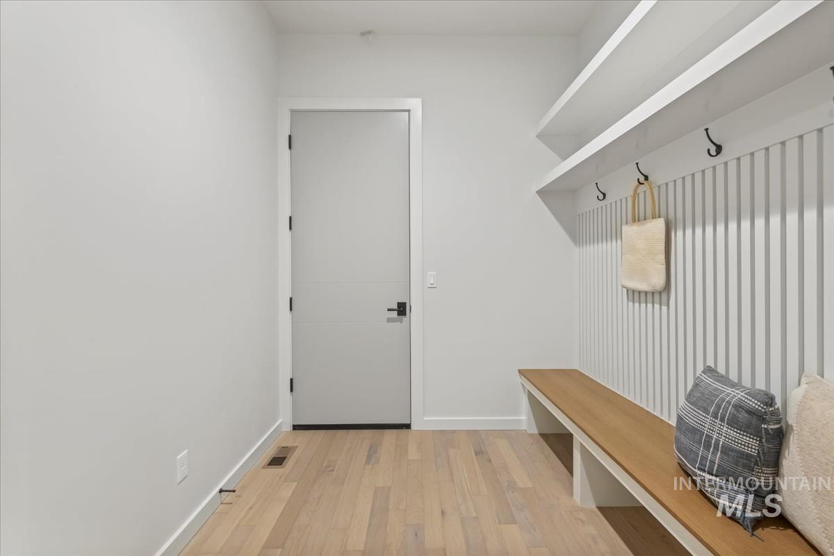 Mudroom featuring light wood-style floors and baseboards