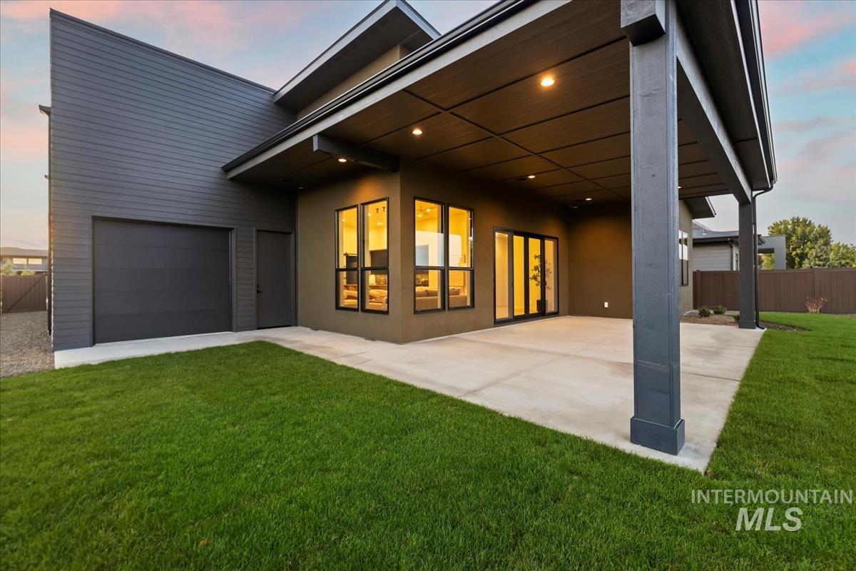 Back of house at dusk featuring a large patio area