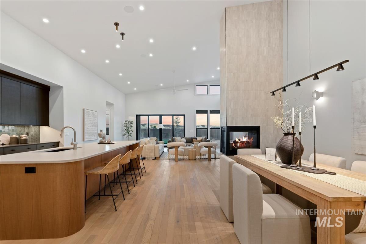 Kitchen featuring modern cabinets, a spacious island, recessed lighting, a kitchen breakfast bar, and light wood-style floors