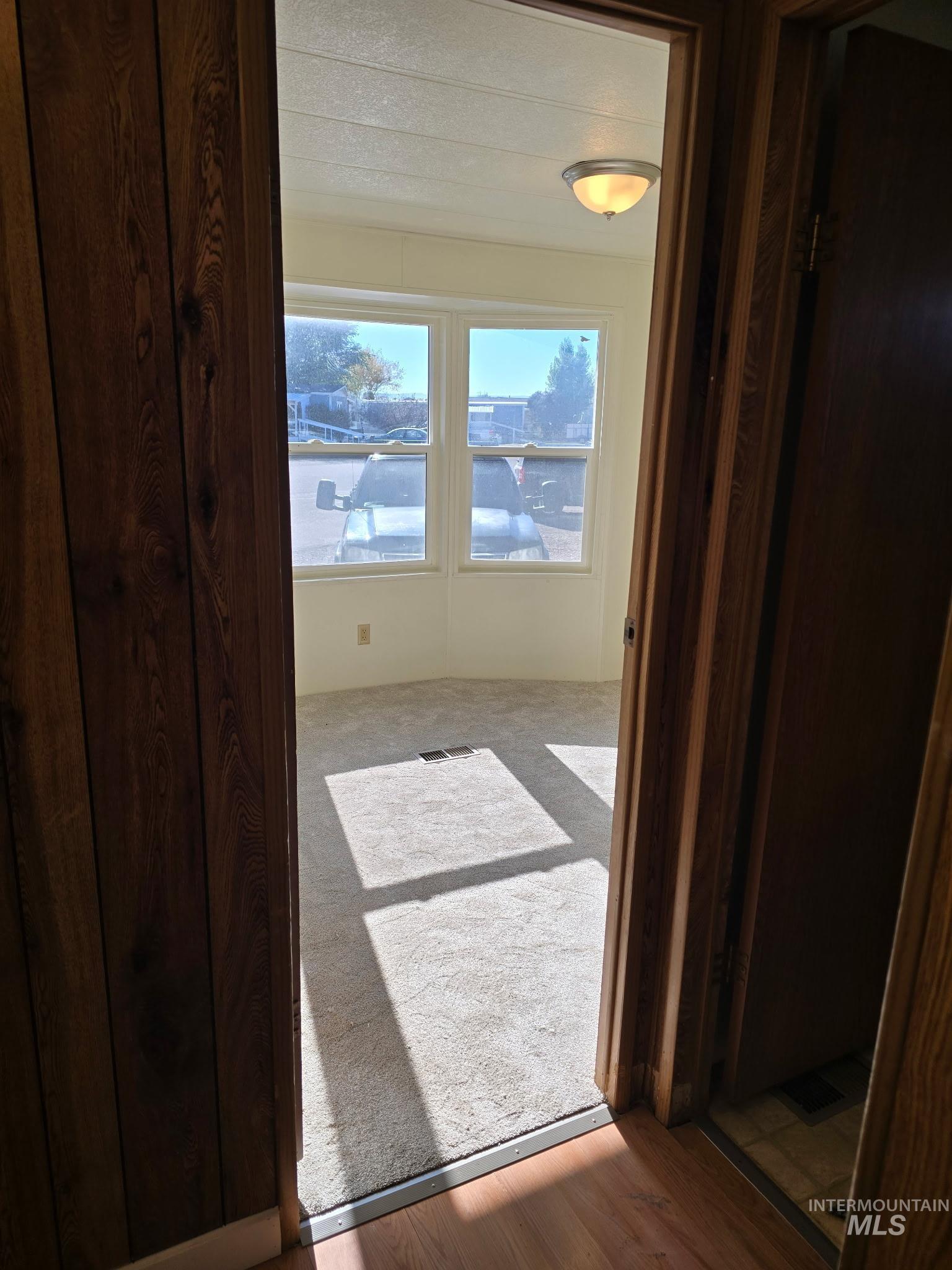Hall featuring wood finished floors and carpet