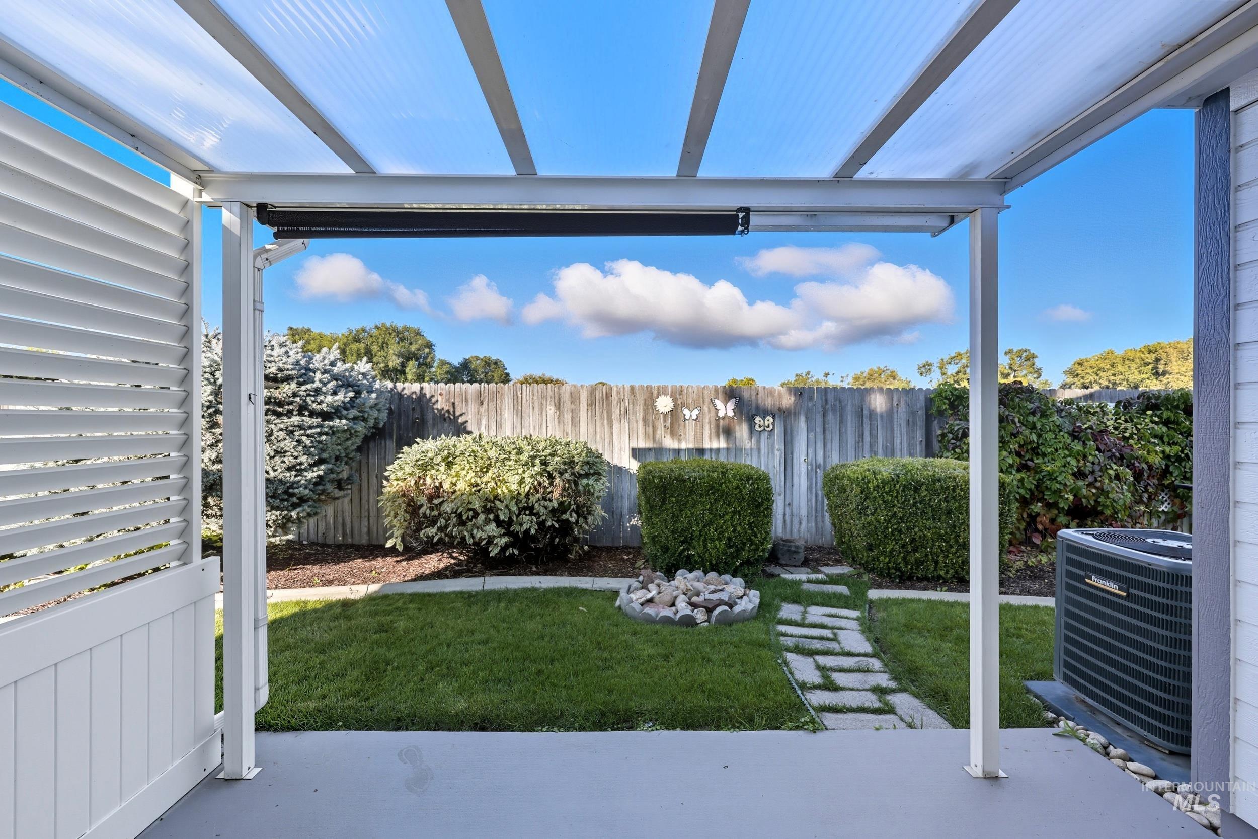 Fenced backyard with a pergola and a patio area