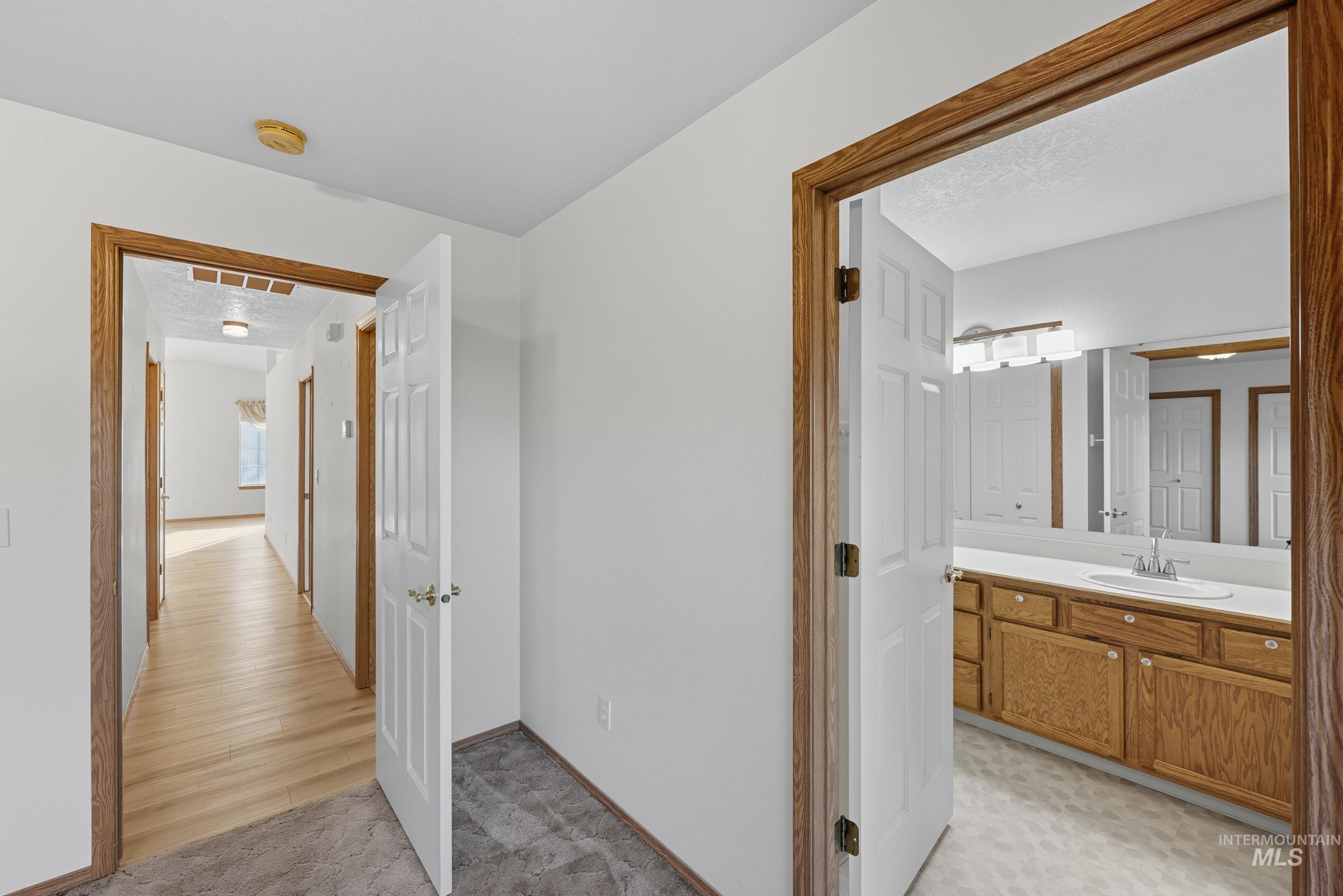 Hall featuring a sink and baseboards