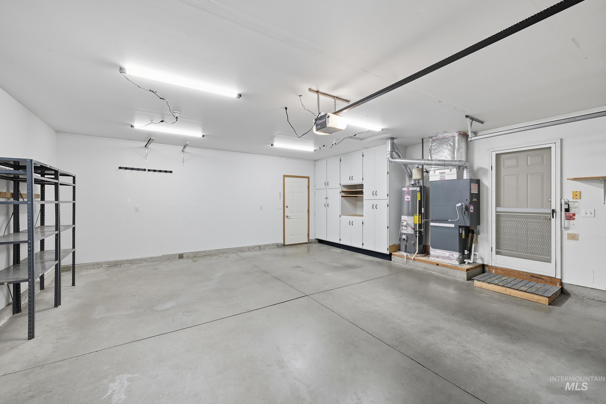 Garage featuring gas water heater and a garage door opener