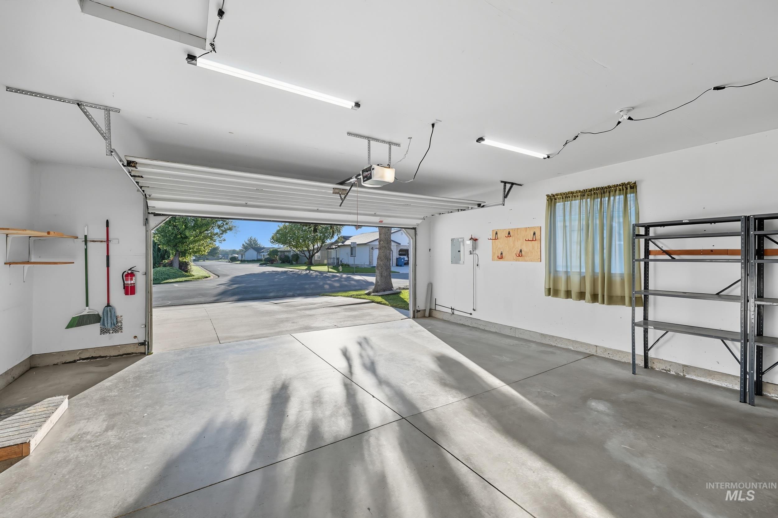 Garage featuring a garage door opener and electric panel