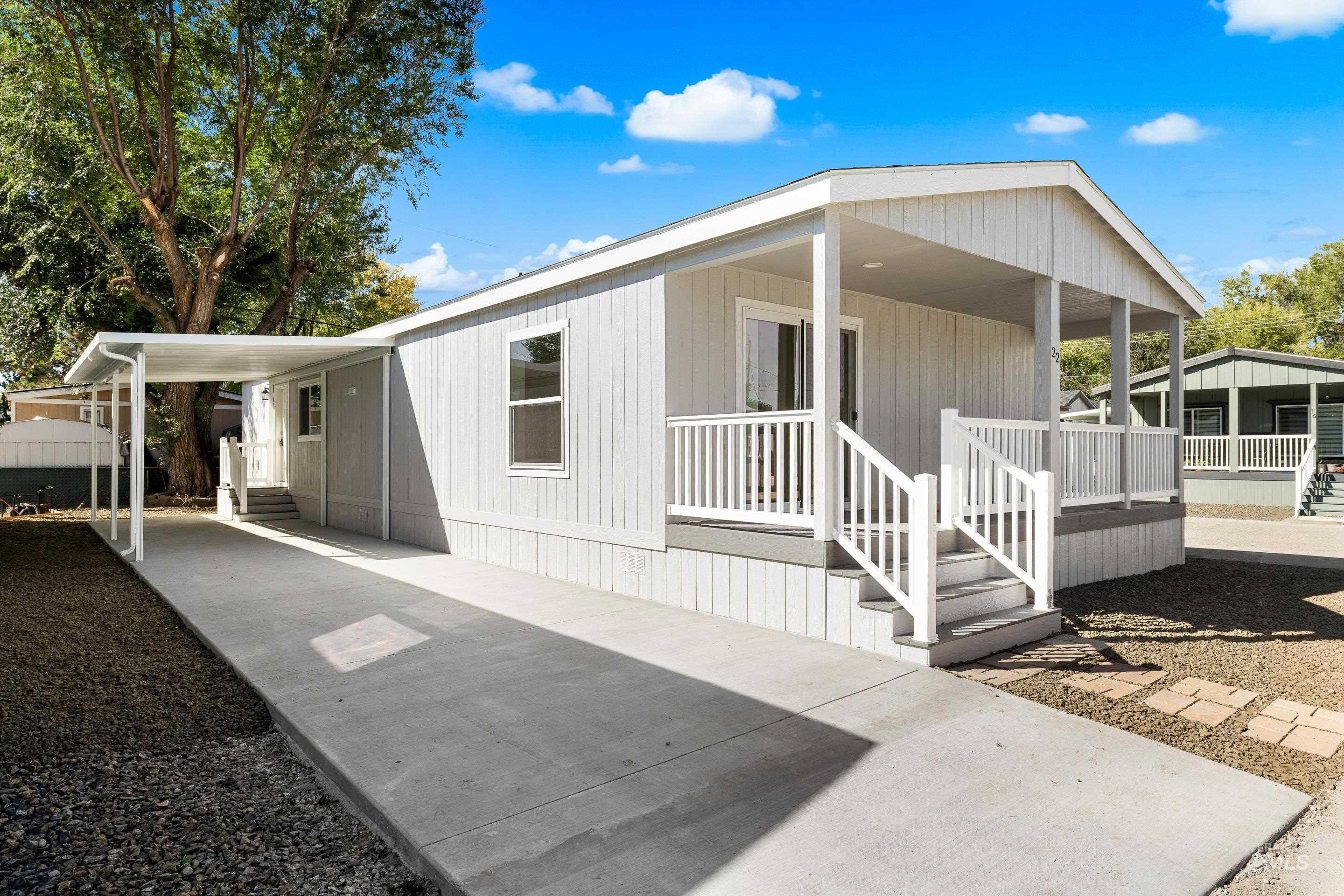 Back of property featuring a porch, a carport, and driveway