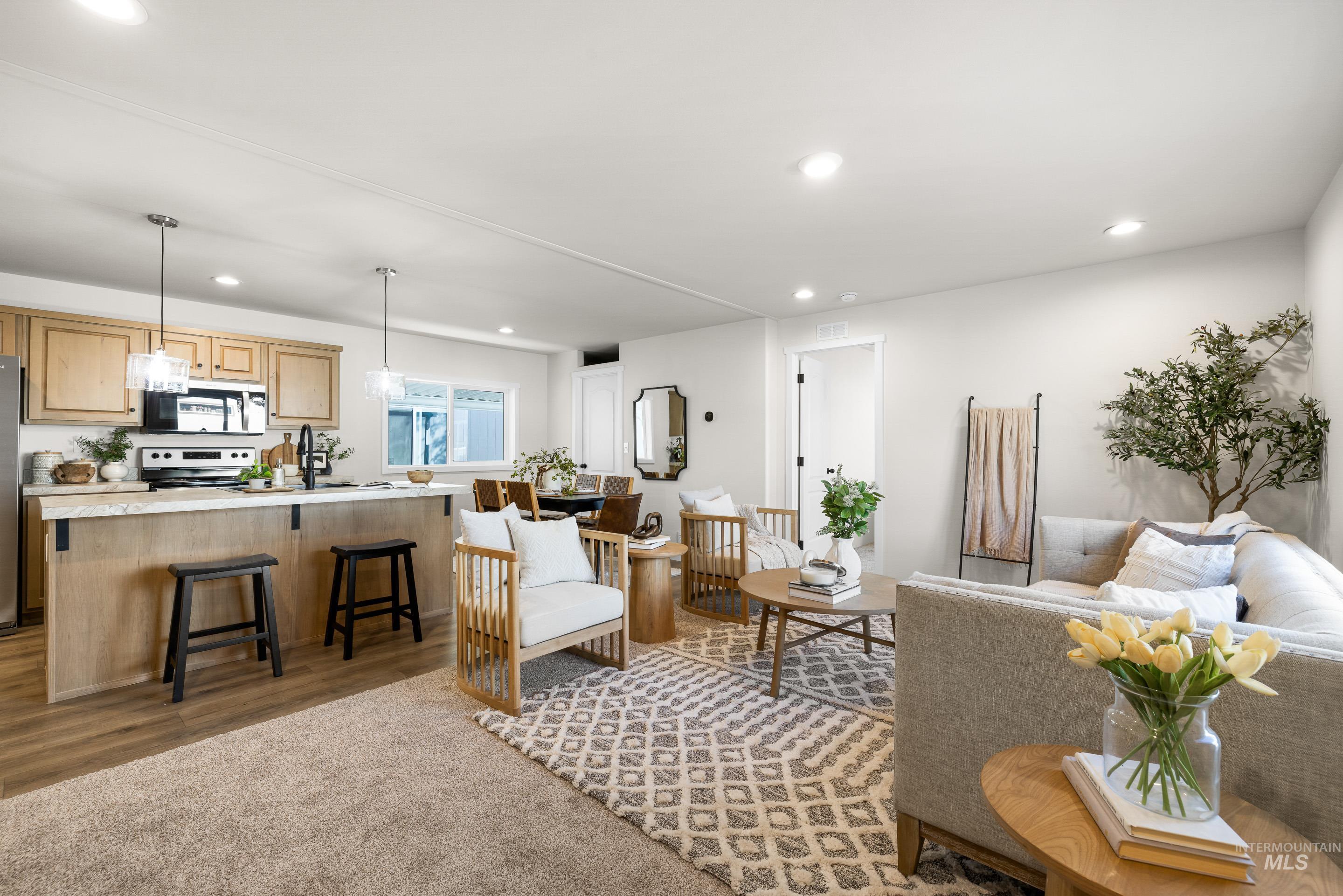 Living room with recessed lighting, wood finished floors, and carpet