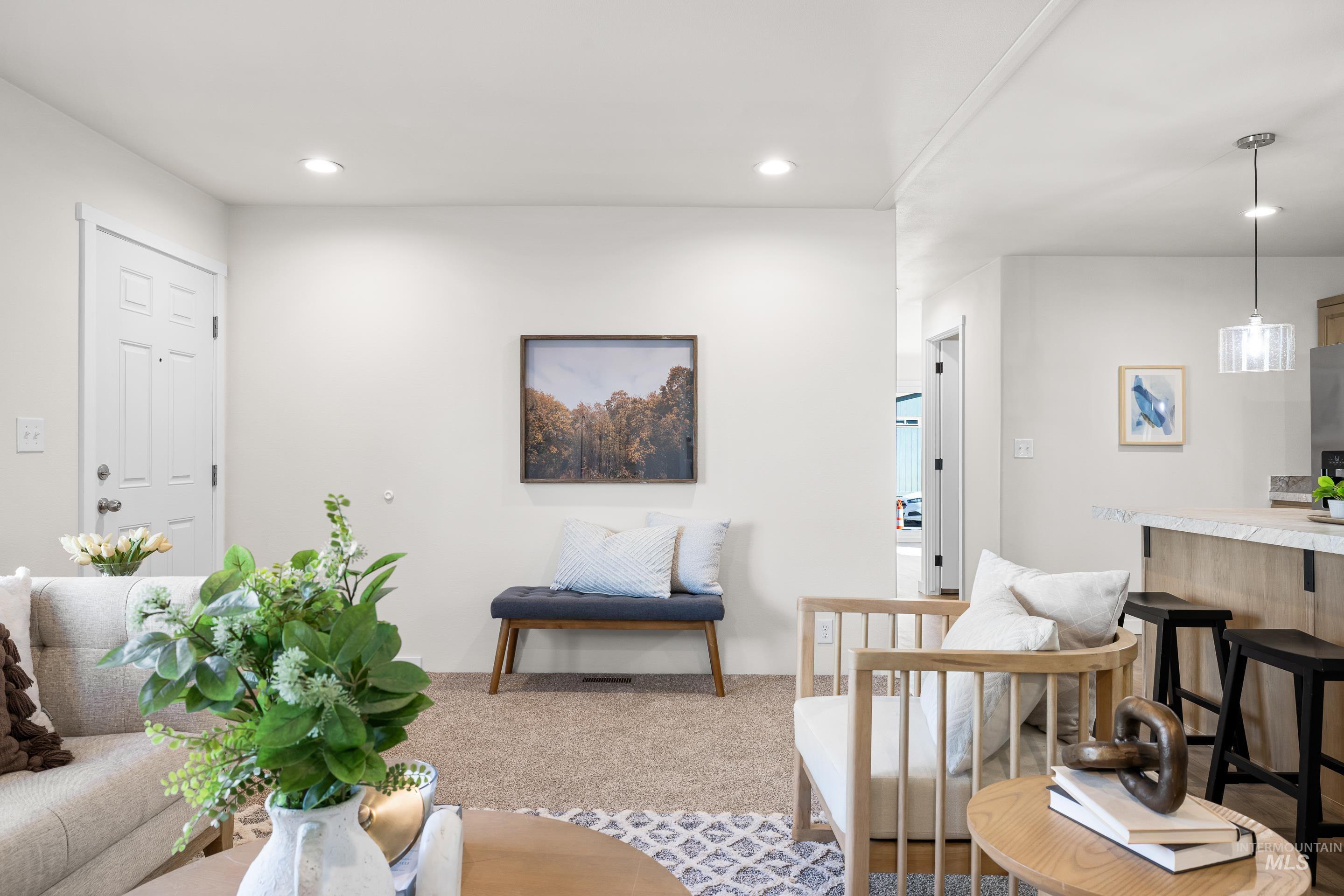 Living area featuring light colored carpet and recessed lighting