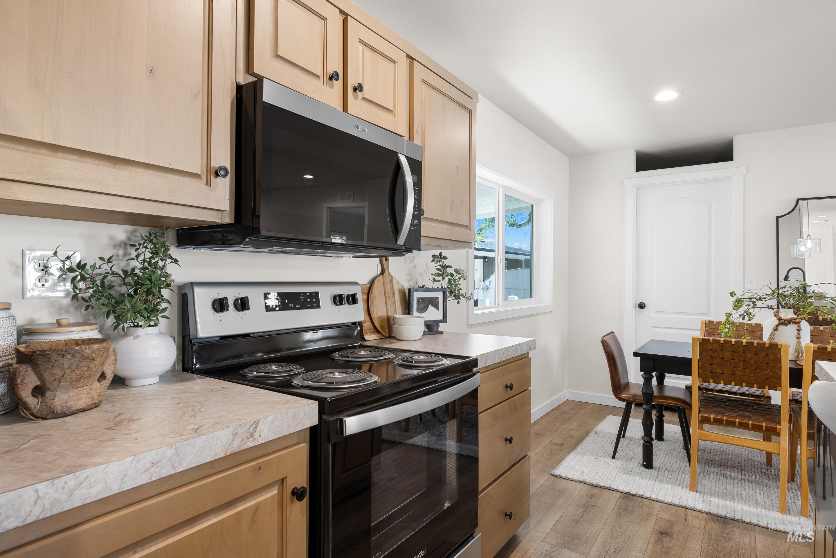 Kitchen featuring range with electric stovetop, light wood-style flooring, light countertops, light brown cabinetry, and recessed lighting