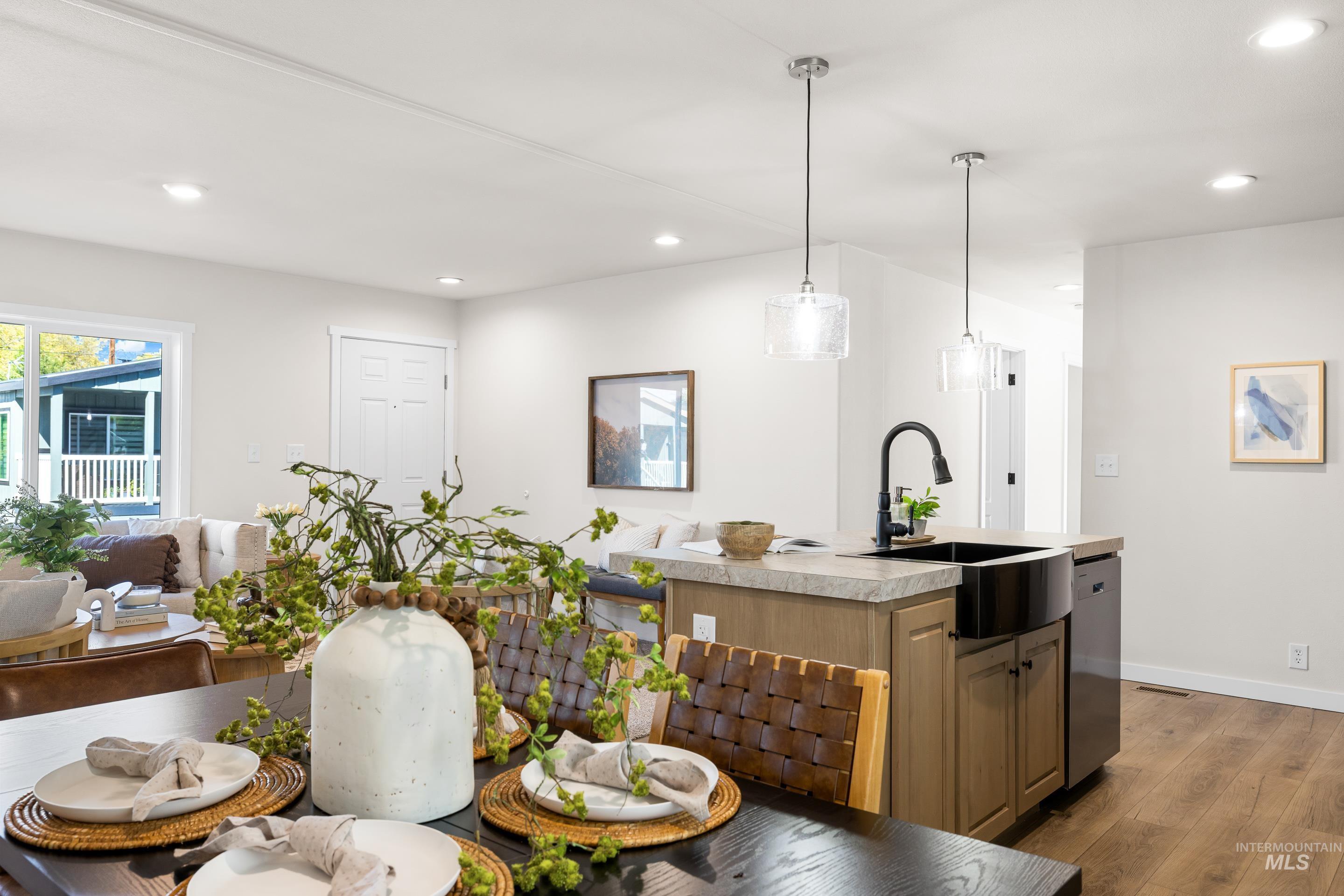 Kitchen featuring open floor plan, light countertops, light wood-style floors, recessed lighting, and decorative light fixtures