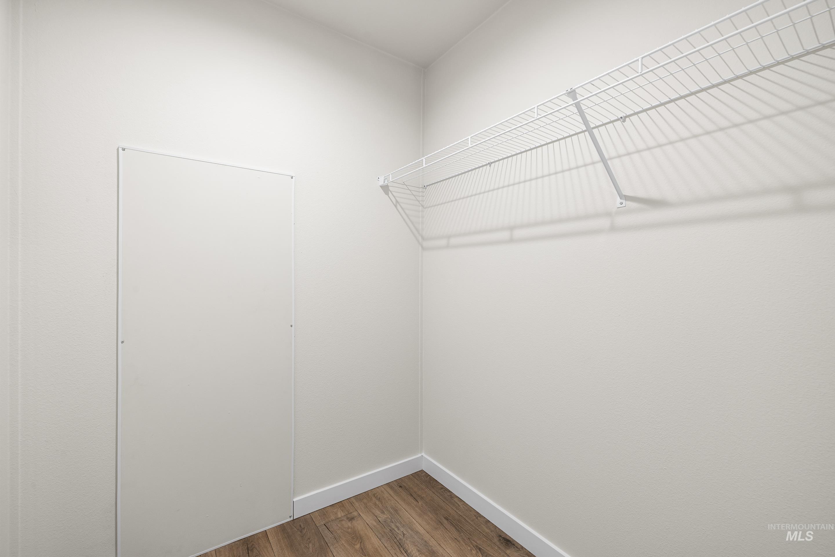 Spacious closet with dark wood-style floors