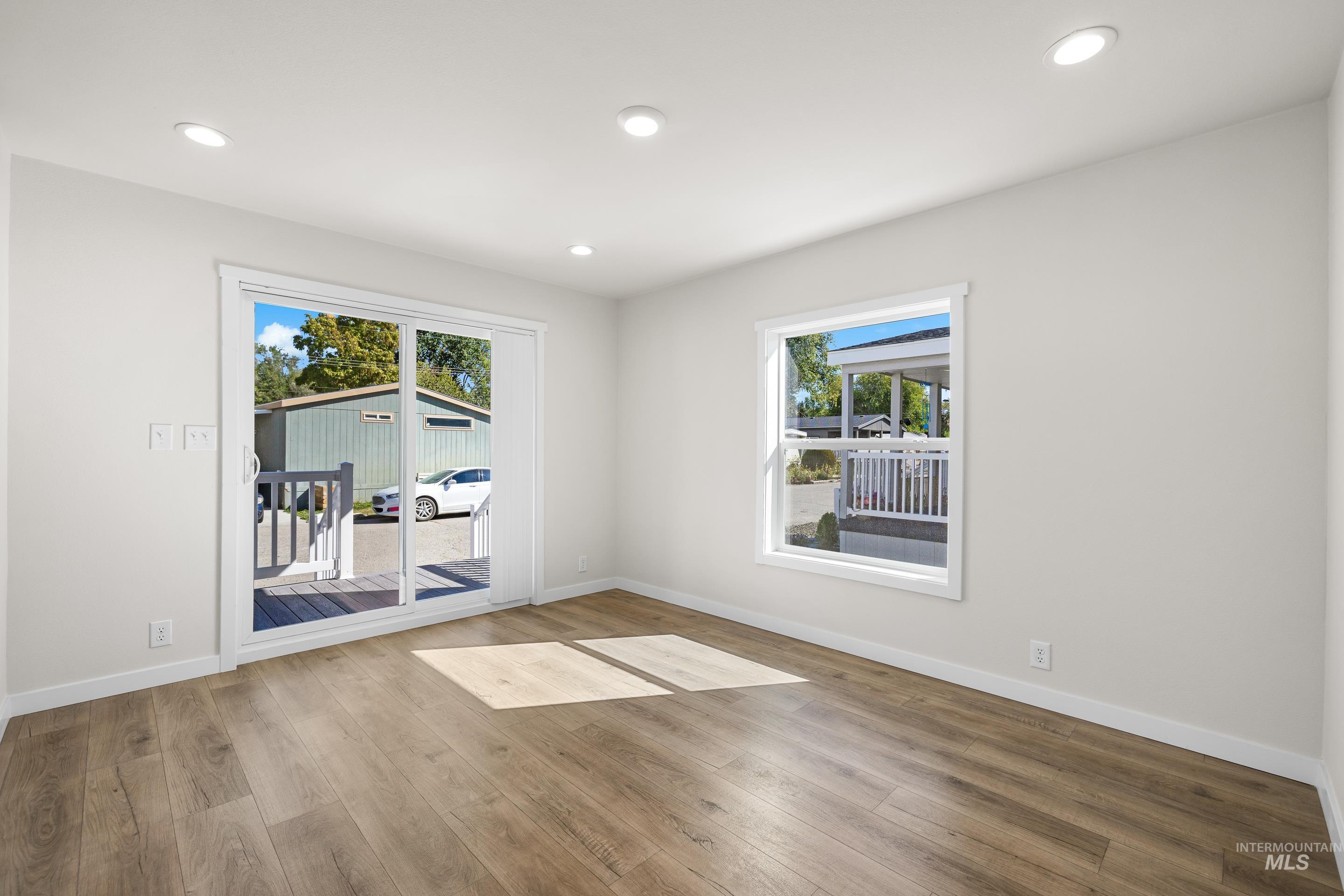Spare room featuring recessed lighting, plenty of natural light, and wood finished floors