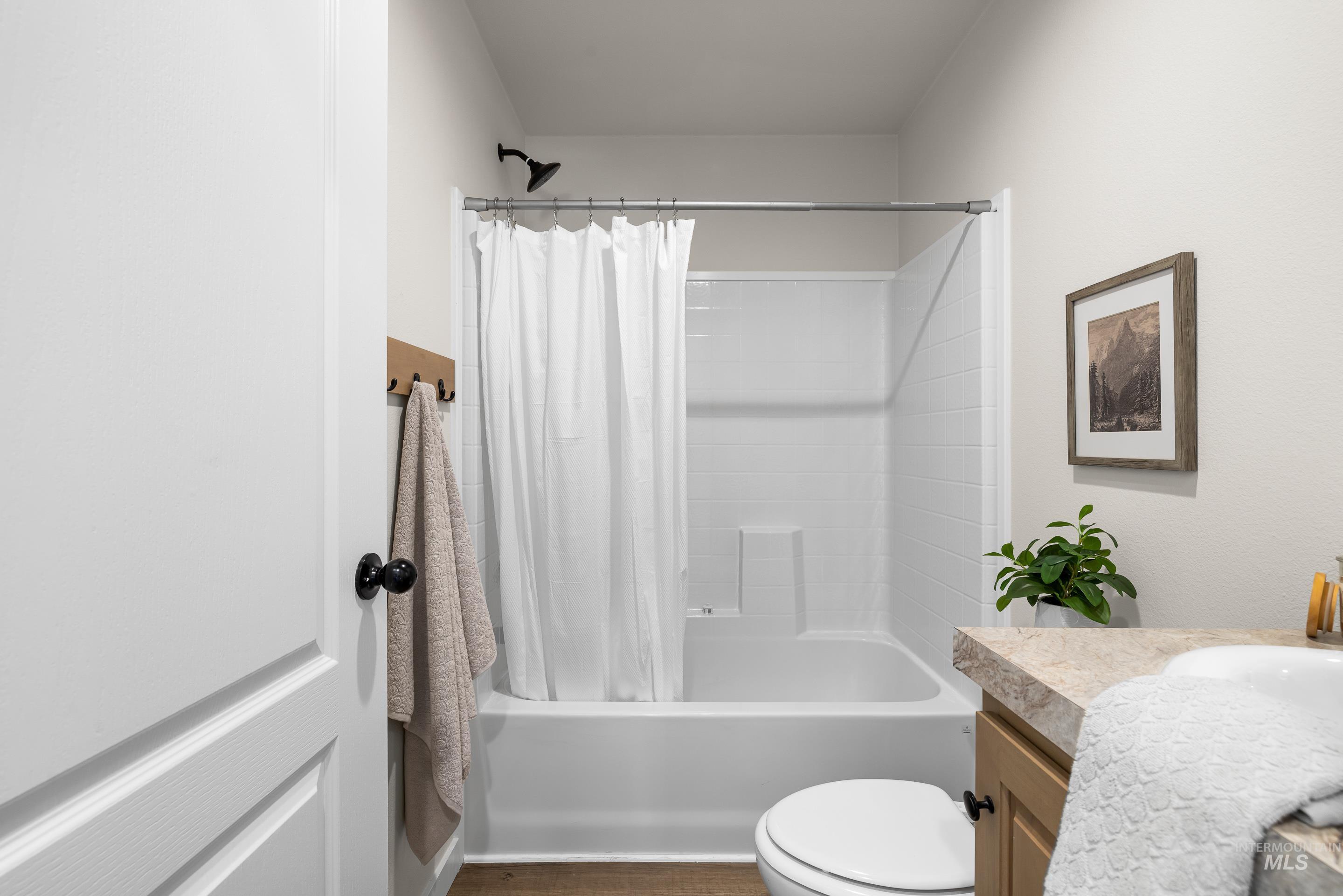 Bathroom featuring shower / bathtub combination with curtain and vanity