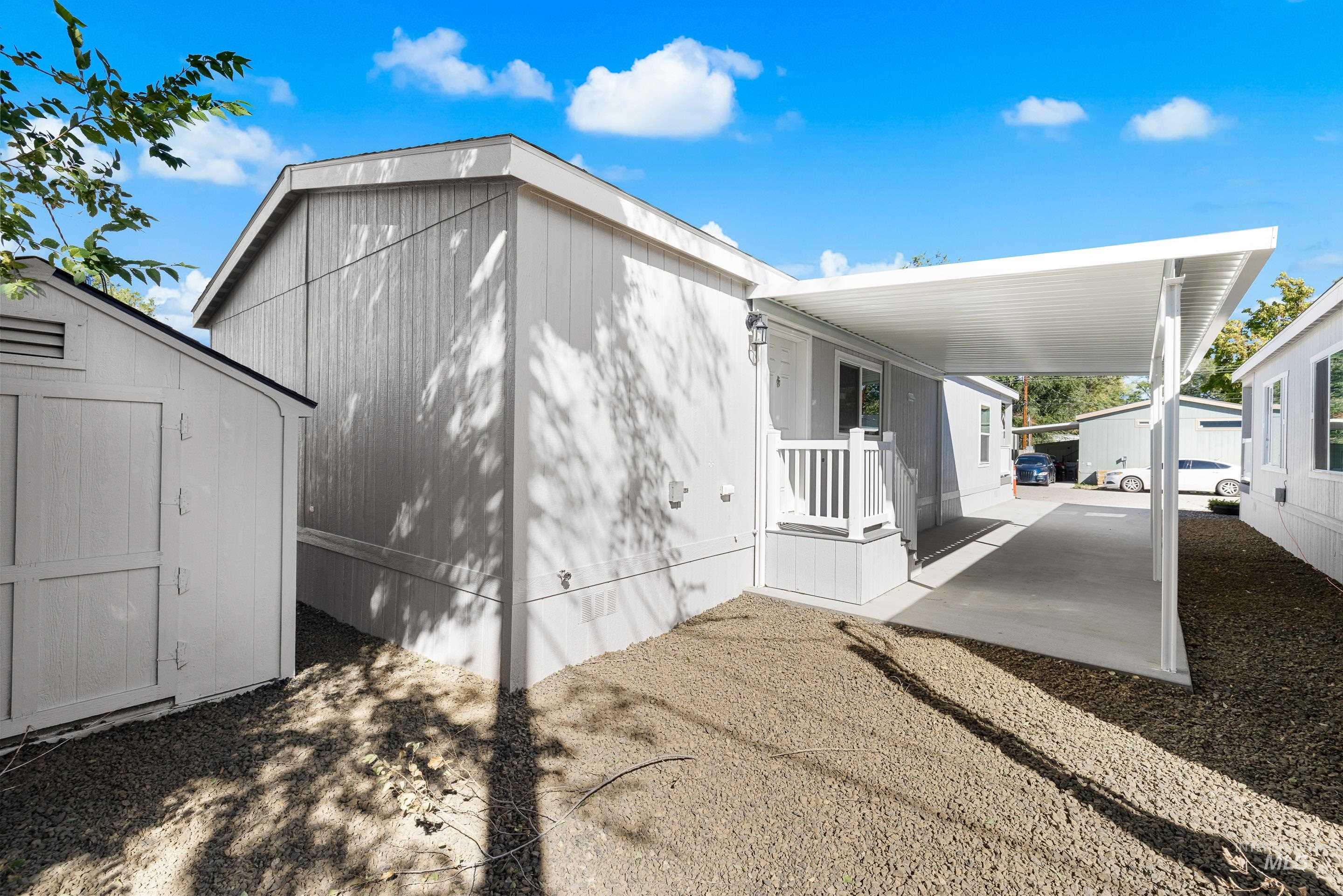 View of side of property featuring covered porch and a storage unit