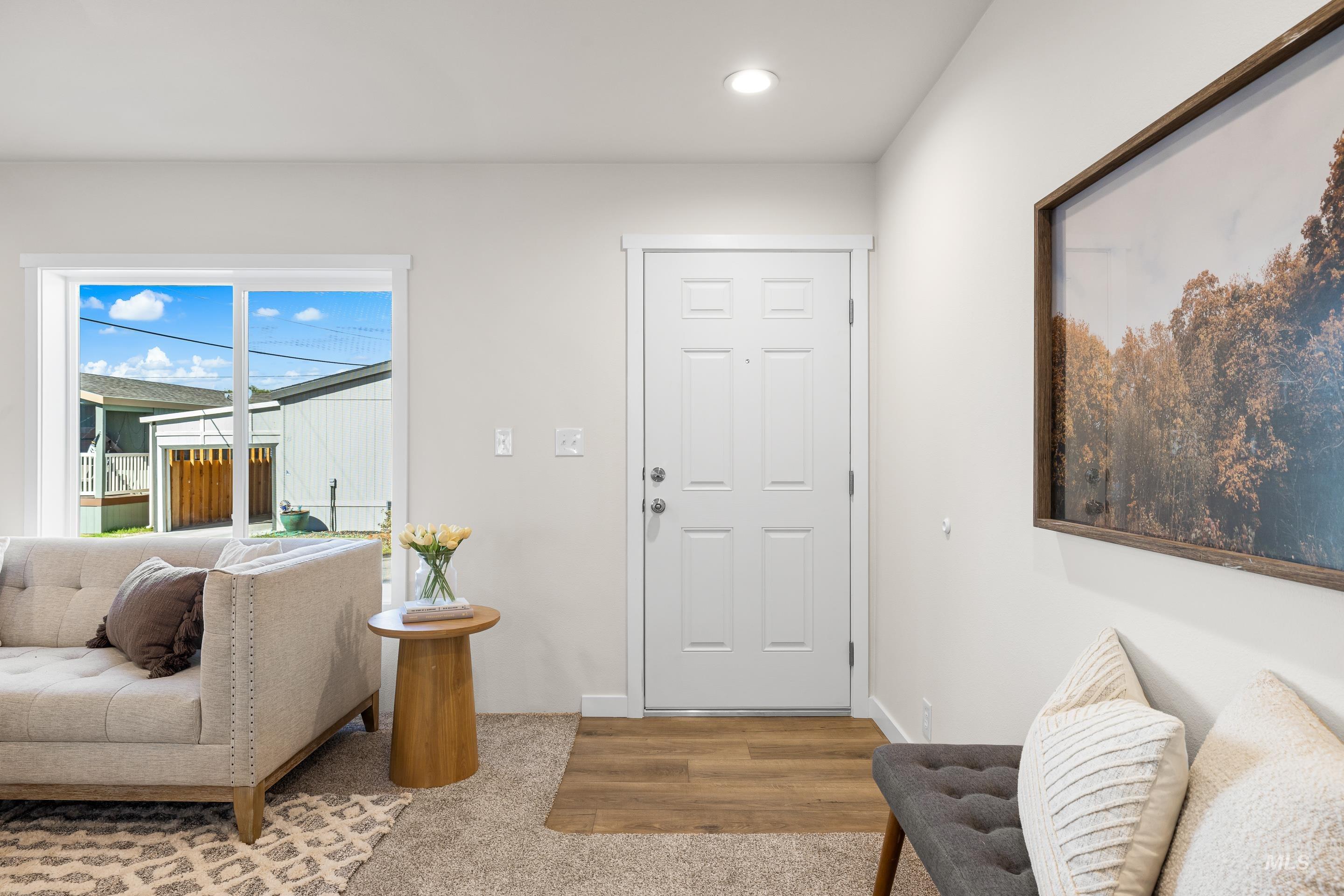 Carpeted foyer with recessed lighting and wood finished floors