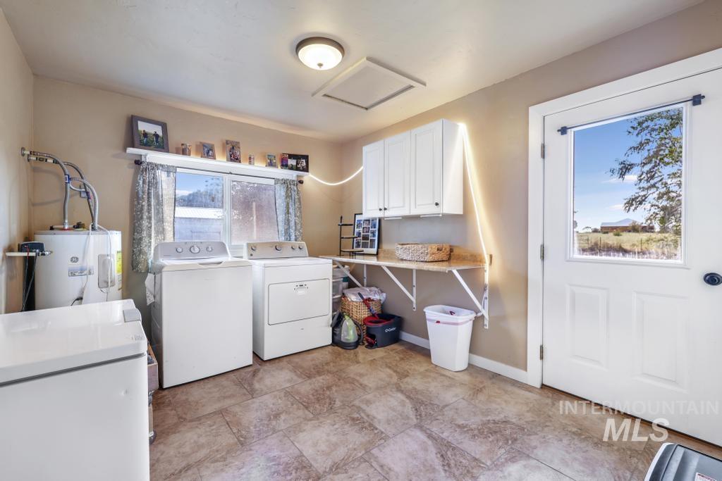 Washroom featuring attic access, independent washer and dryer, and water heater