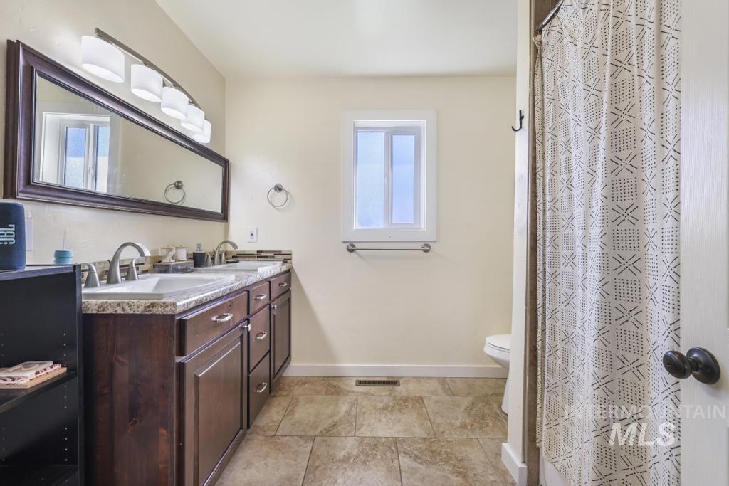 Bathroom with double vanity and curtained shower