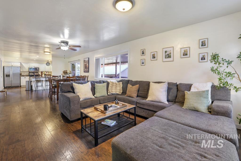 Living area with dark wood finished floors and ceiling fan