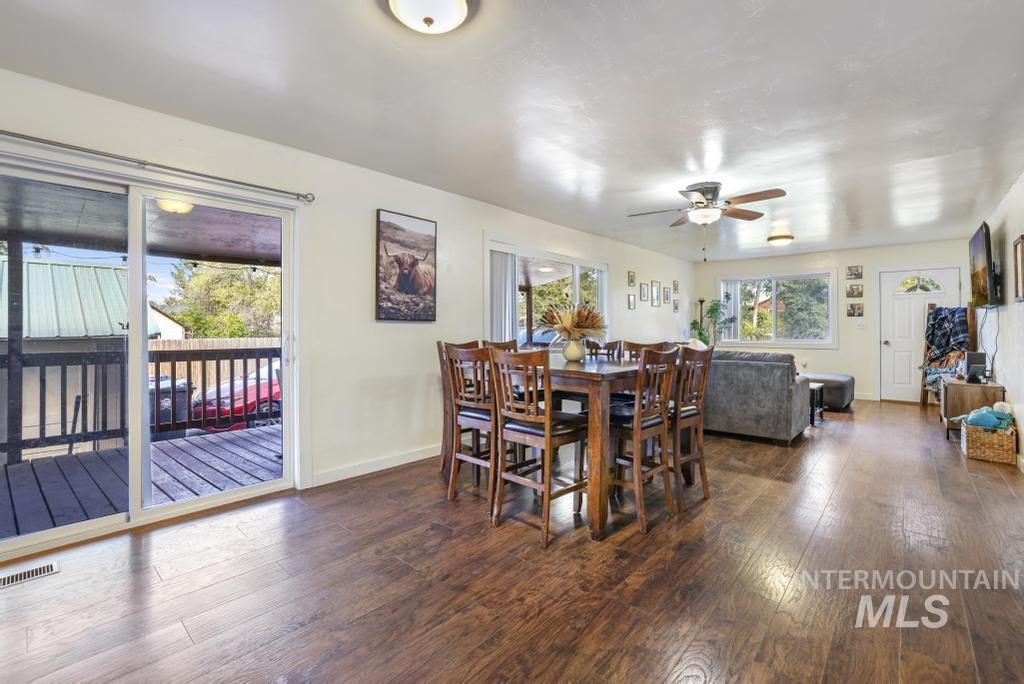 Dining space featuring dark wood-type flooring and ceiling fan