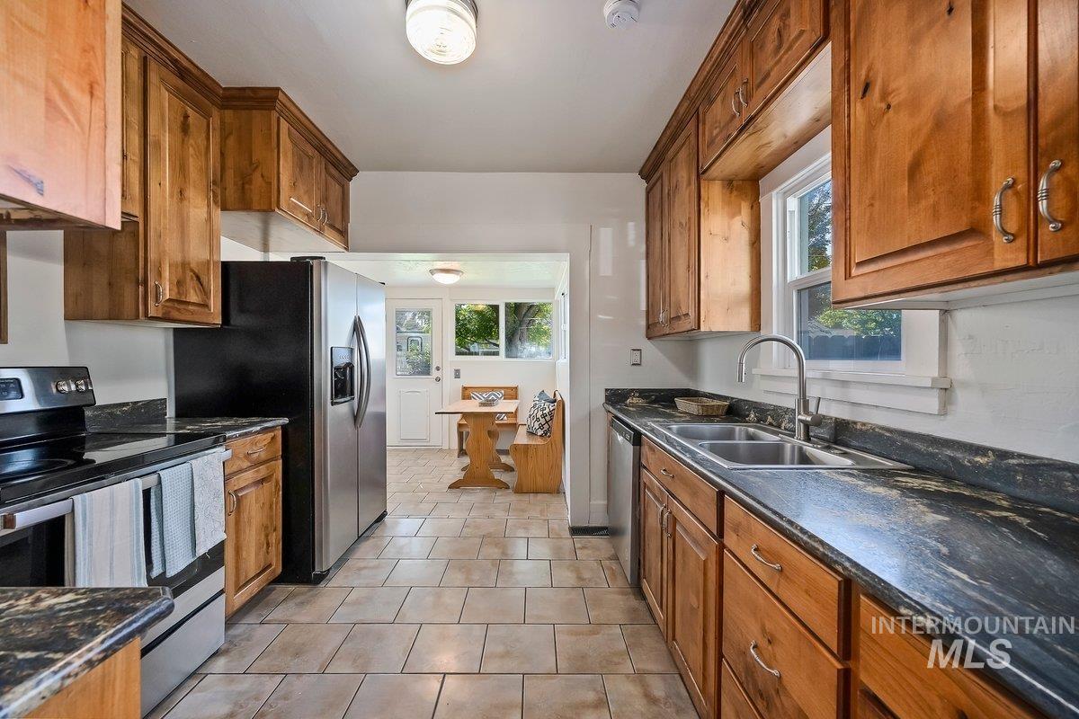 Kitchen with stainless steel appliances, brown cabinets, and healthy amount of natural light