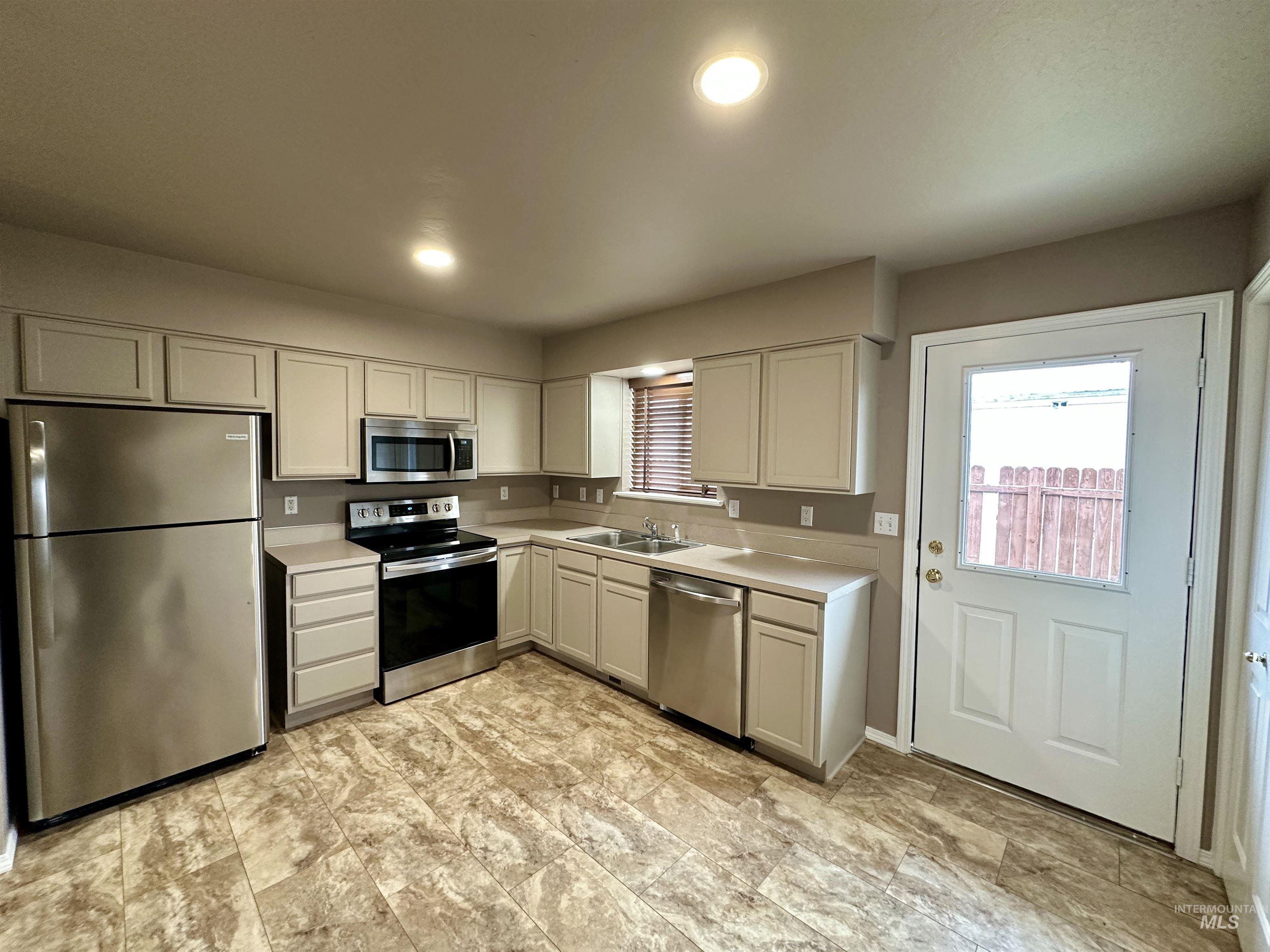 Kitchen with appliances with stainless steel finishes, light countertops, recessed lighting, and white cabinetry