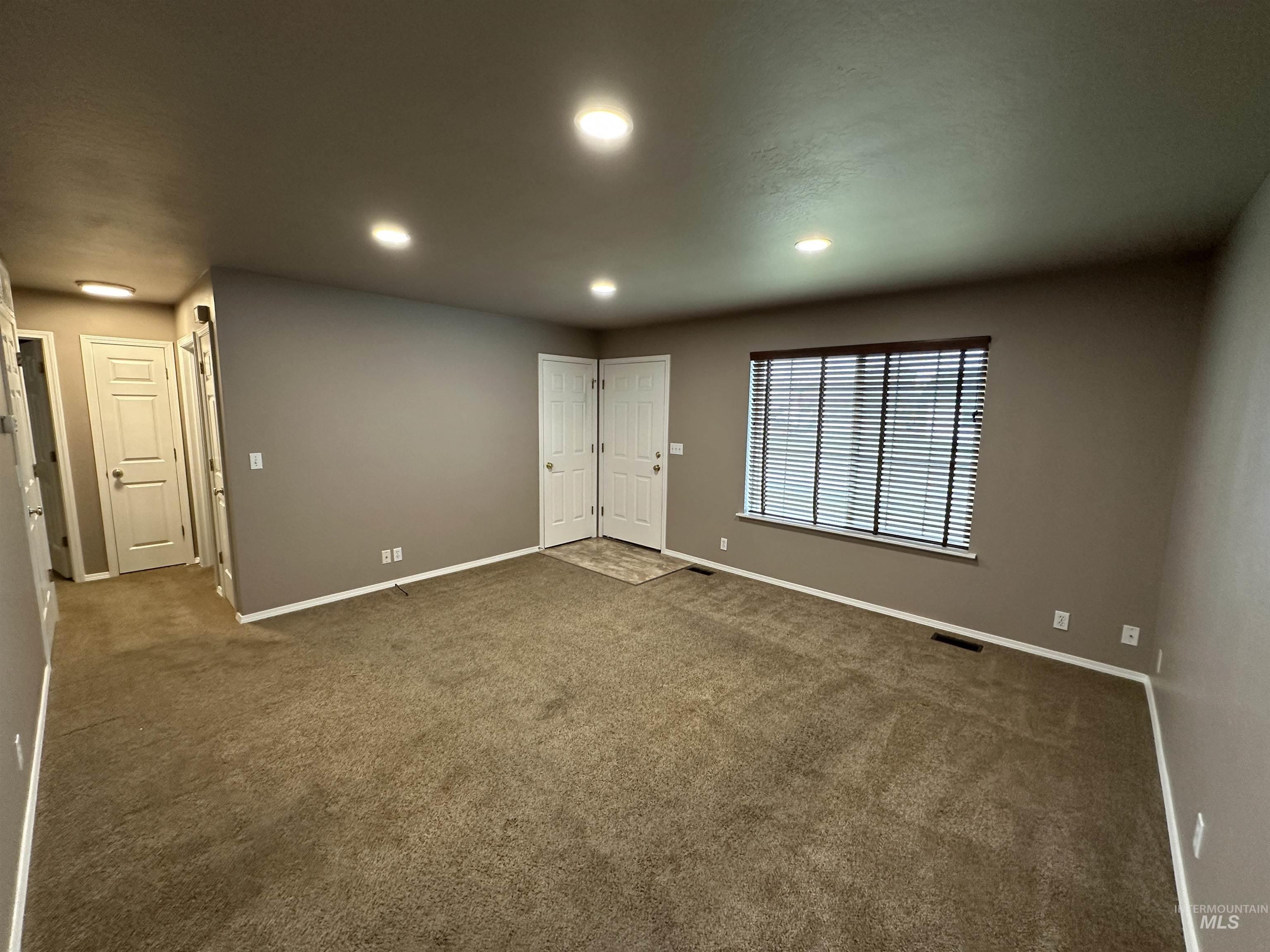 Carpeted empty room featuring recessed lighting and baseboards