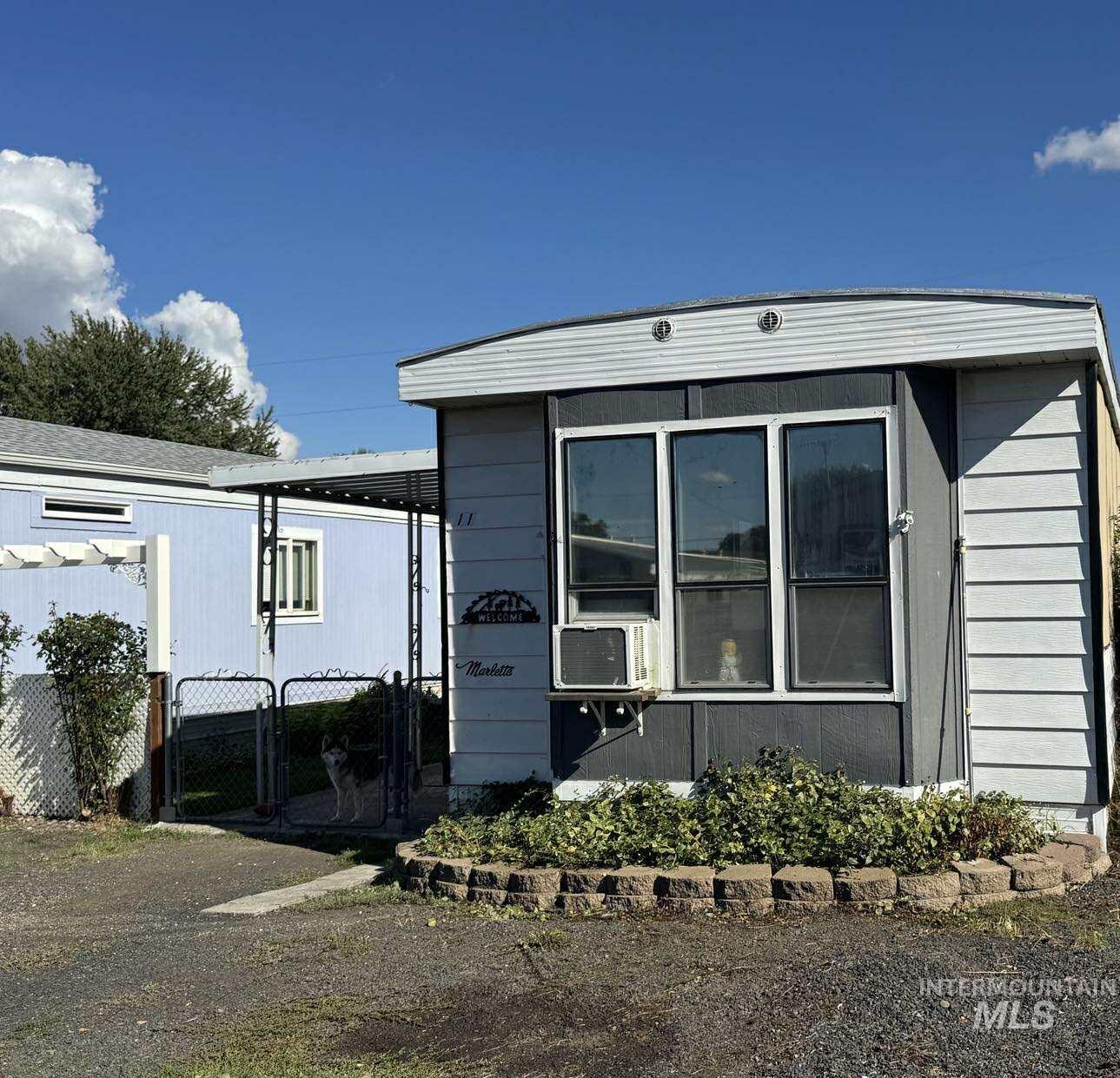 View of property exterior featuring a gate, a fenced front yard, and cooling unit