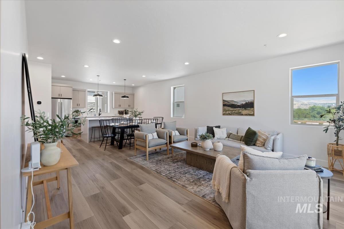 Living room with light wood-type flooring, recessed lighting, and plenty of natural light