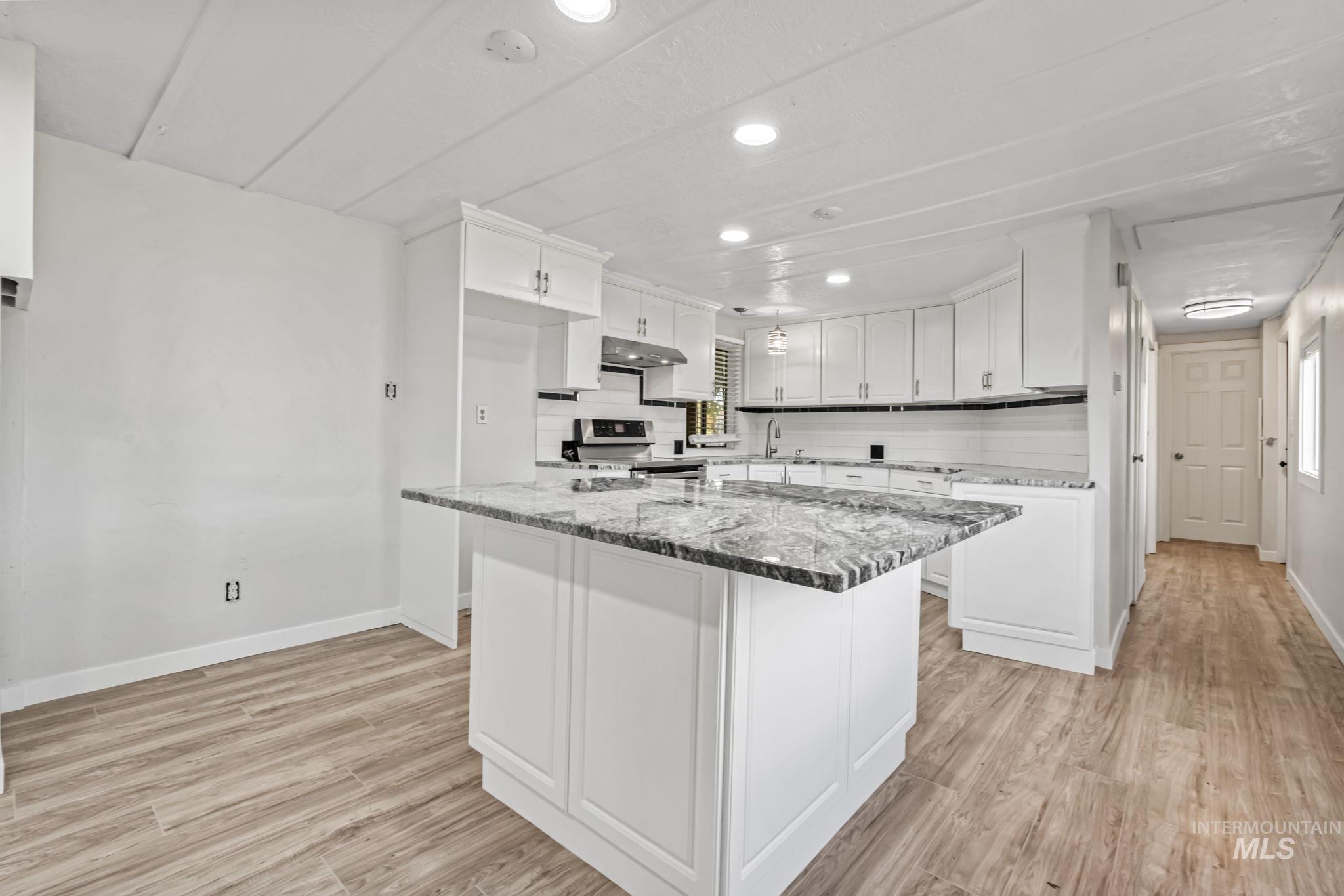 Kitchen featuring white cabinetry, recessed lighting, electric stove, light stone countertops, and light wood-type flooring