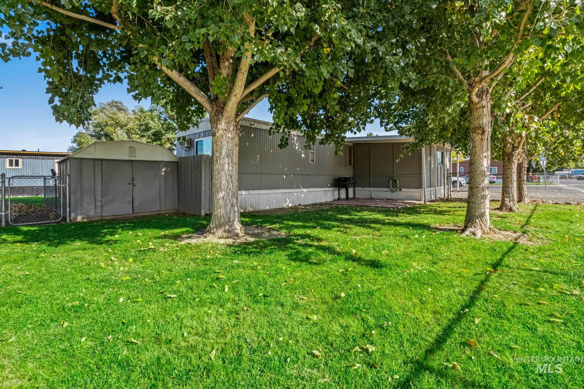 View of yard featuring a storage shed and a gate