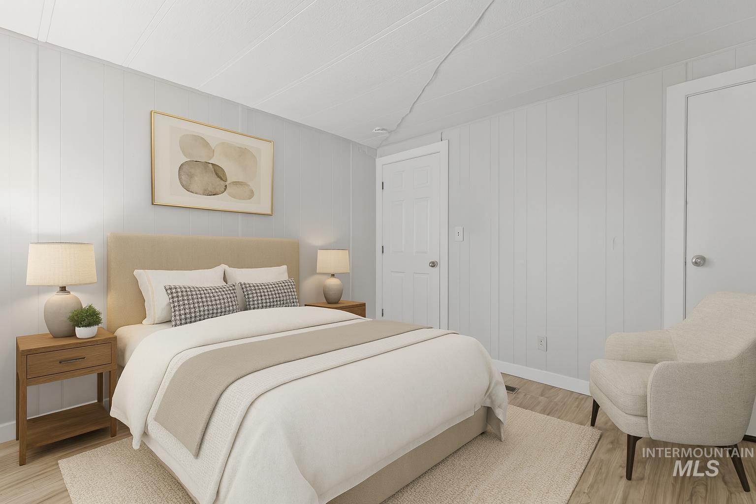 Bedroom featuring light wood-style flooring and wooden walls