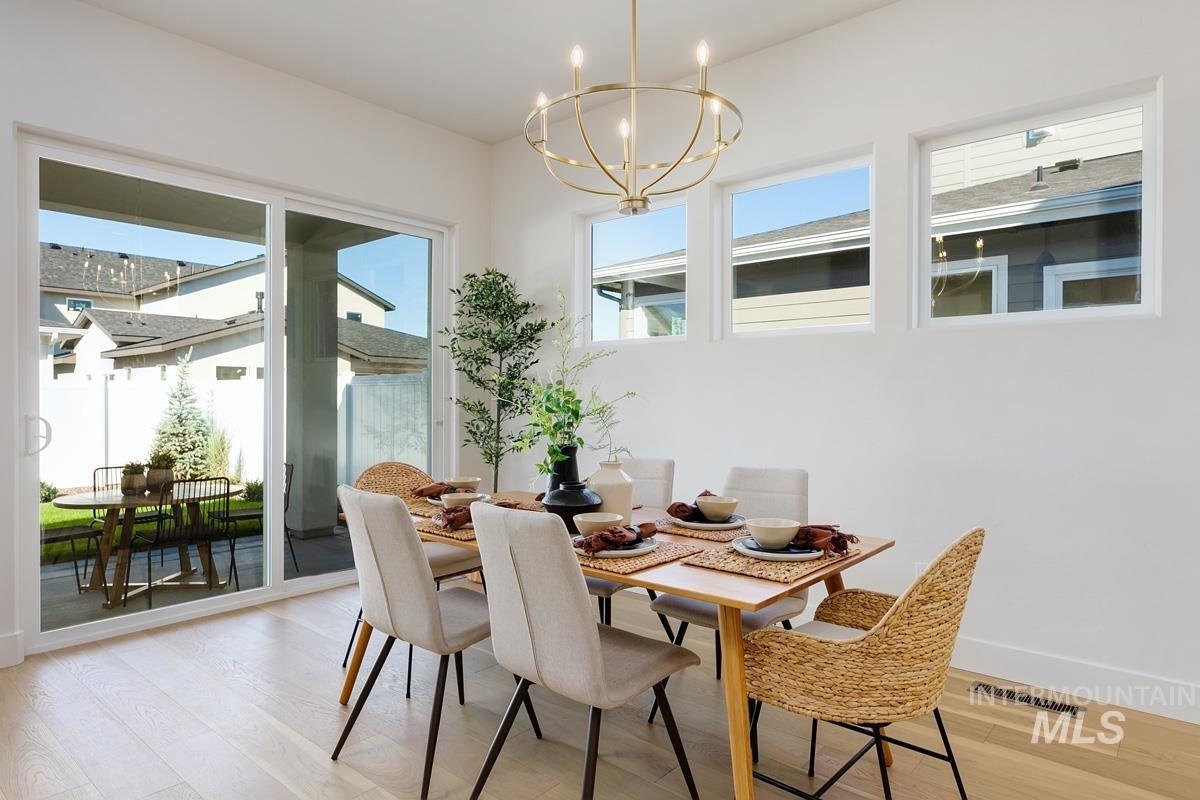 Dining space with light wood finished floors and a chandelier