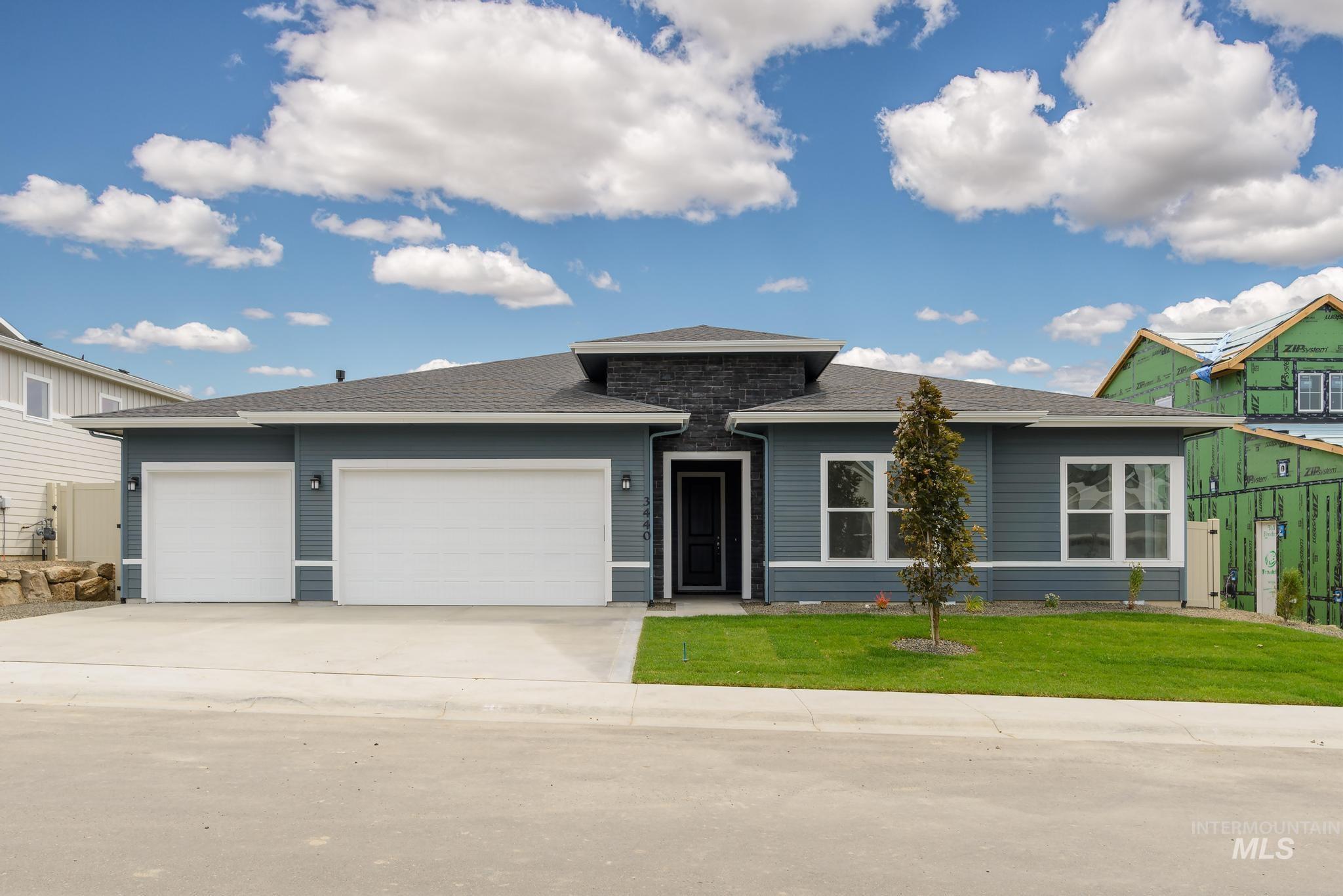View of front of home with a garage, driveway, and a shingled roof