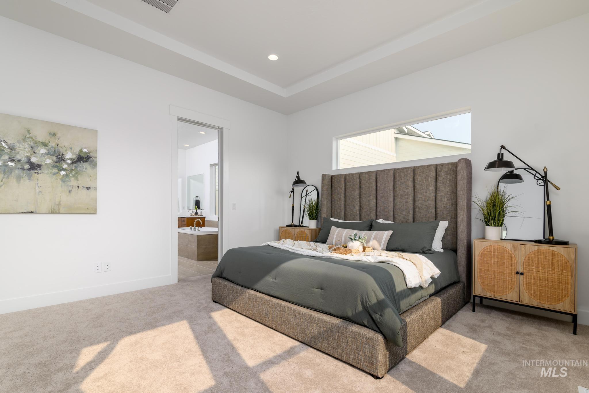 Bedroom with carpet flooring, connected bathroom, recessed lighting, and a tray ceiling