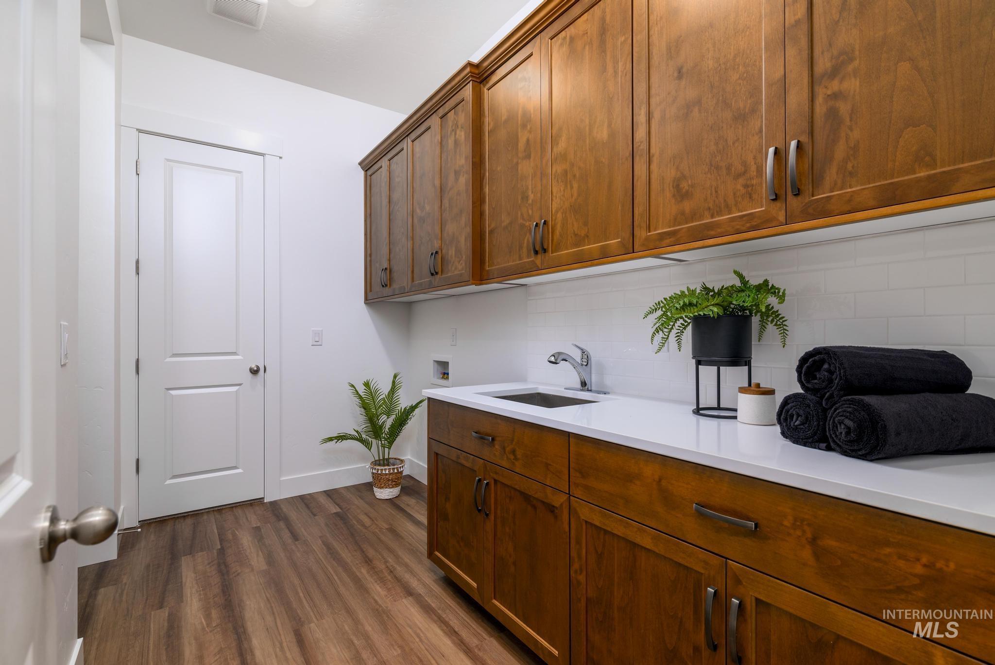 Laundry room featuring dark wood-style flooring, cabinet space, and hookup for a washing machine