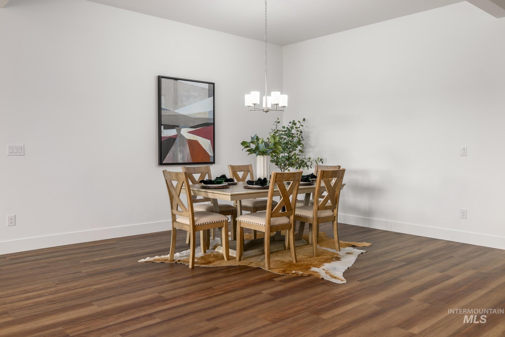 Dining space with dark wood-style flooring and a chandelier