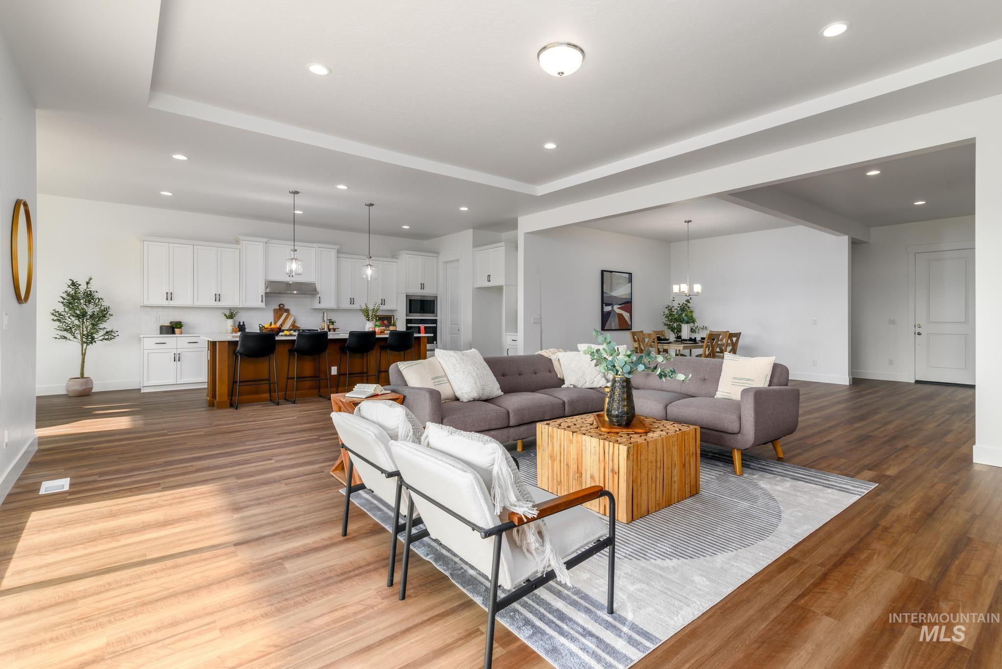 Living room featuring light wood-style floors, recessed lighting, and a tray ceiling