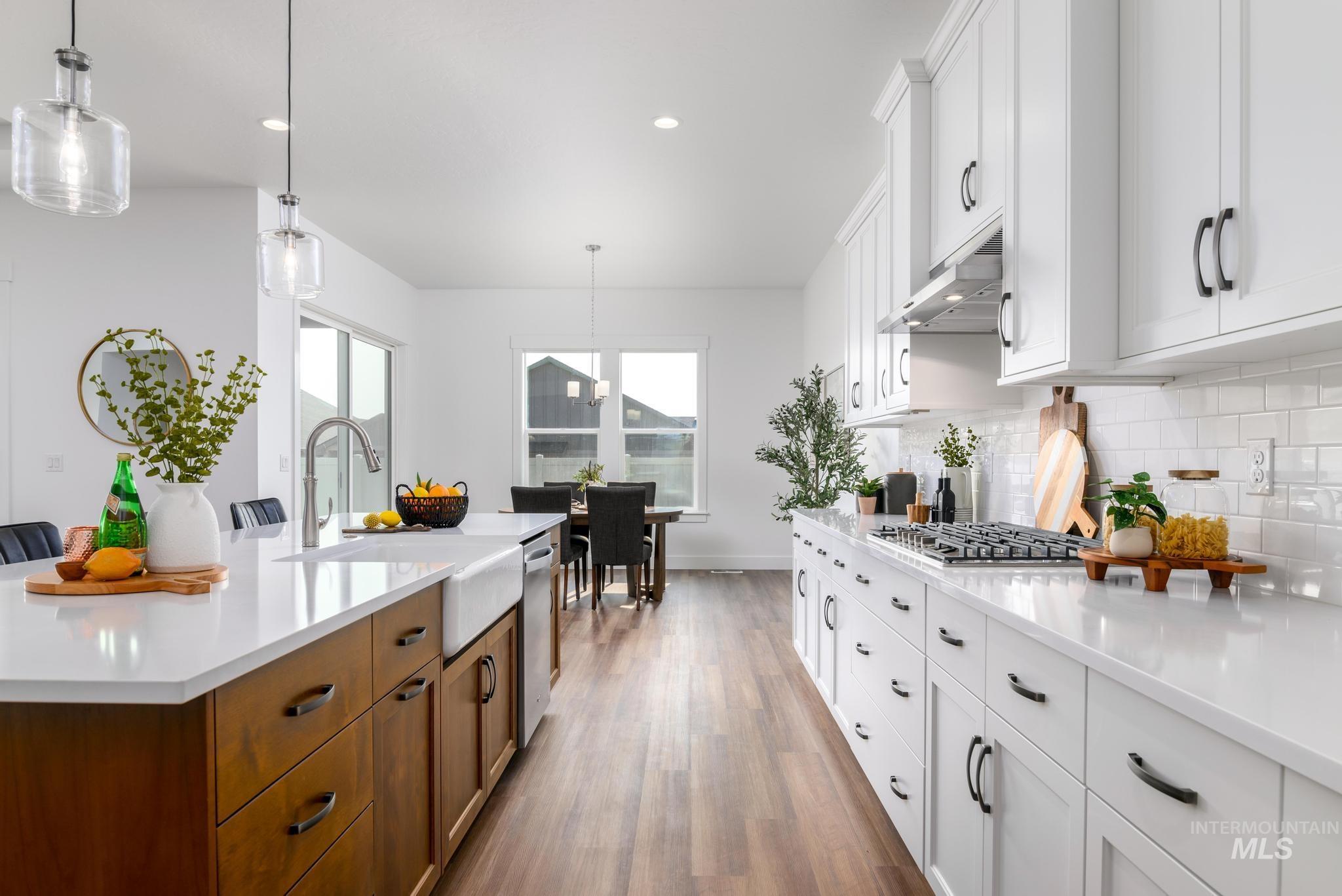 Kitchen featuring white cabinets, decorative light fixtures, dark wood-type flooring, decorative backsplash, and recessed lighting